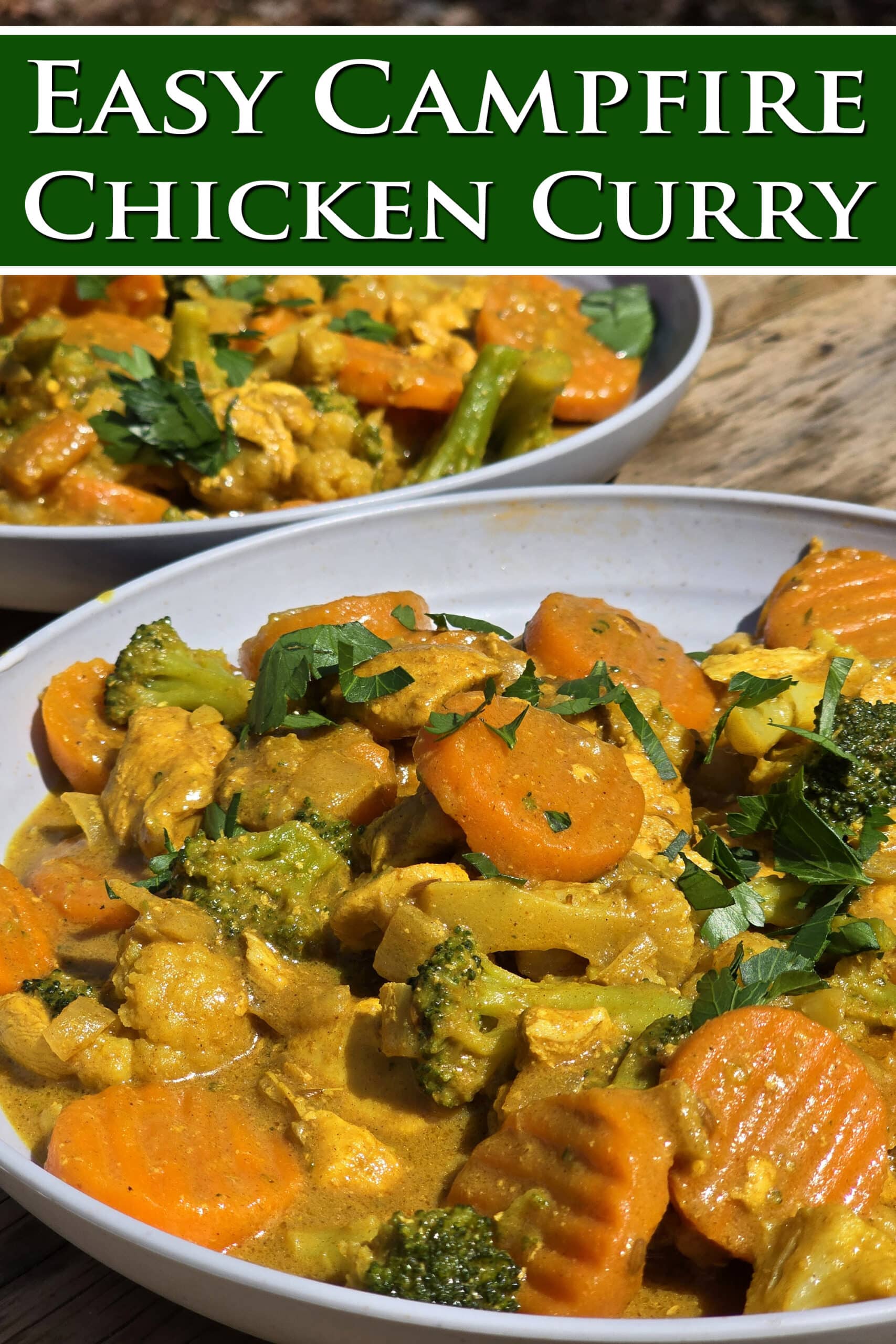 Two bowls of campfire curry chicken with broccoli, carrots, and cauliflower in a yellow sauce. Overlaid text says easy campfire chicken curry.