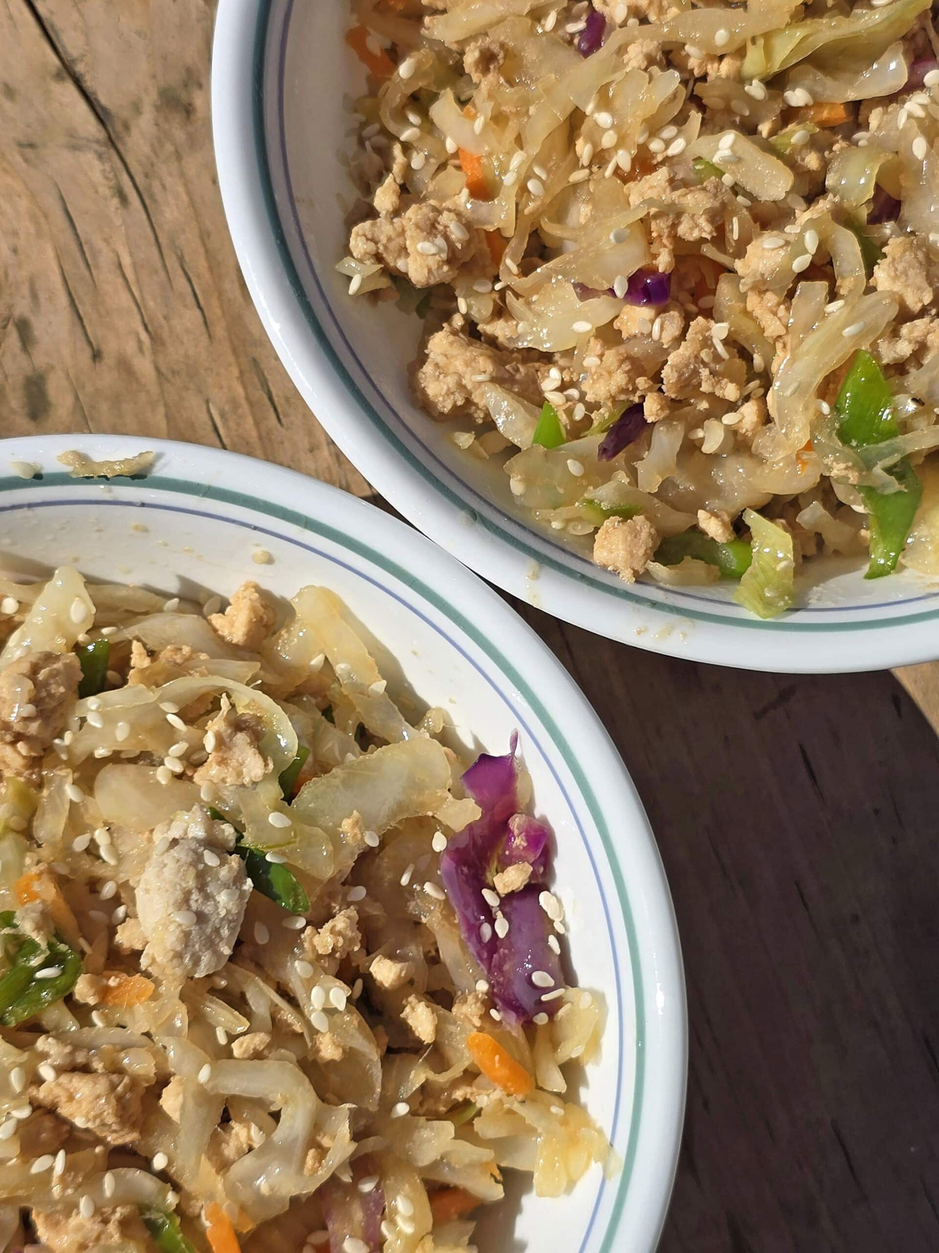 2 bowls of egg roll in a bowl - shredded cabbage, ground beef, and more.