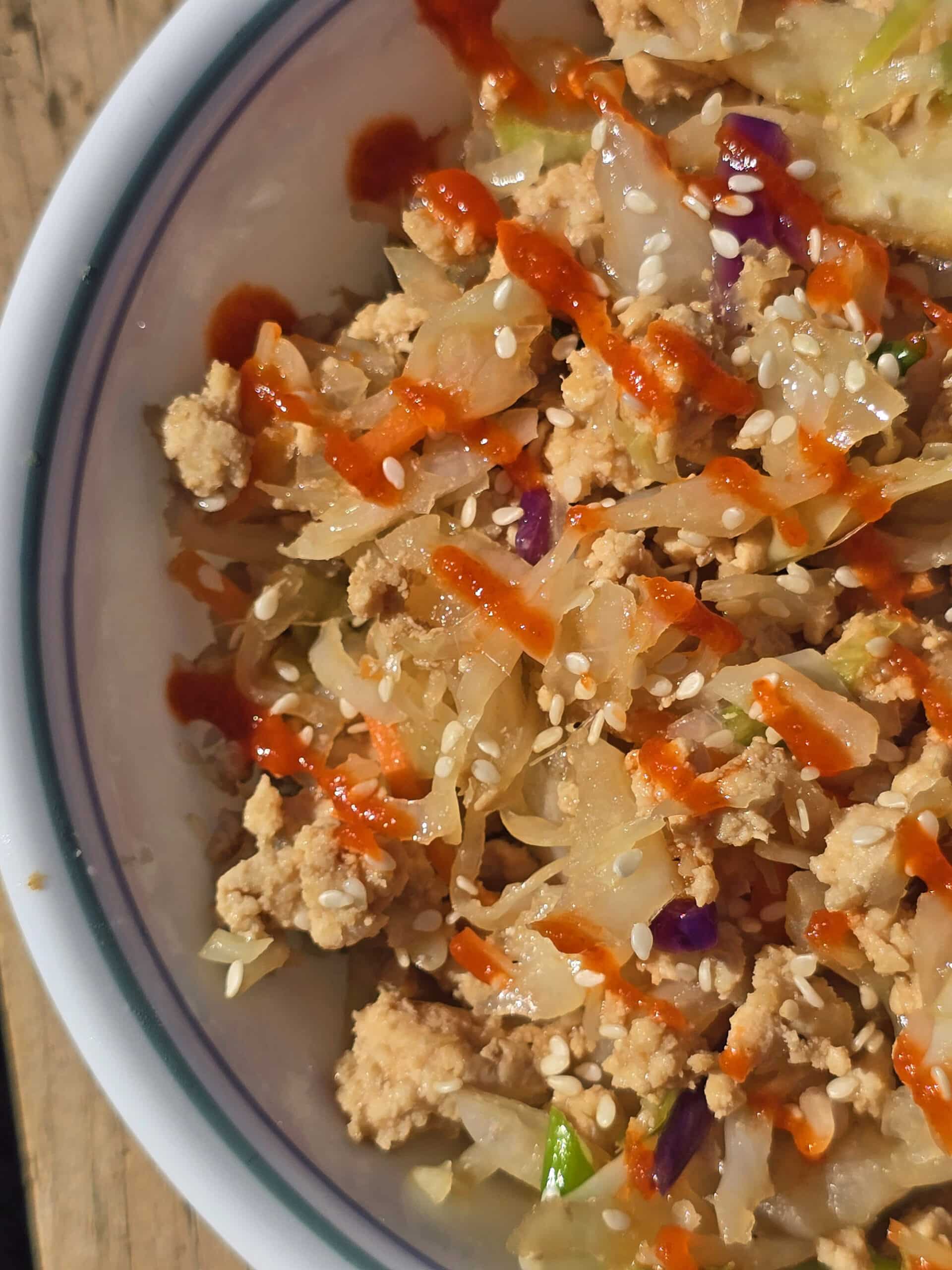 A bowl of egg roll in a pan -shredded cabbage, ground beef, and more.
