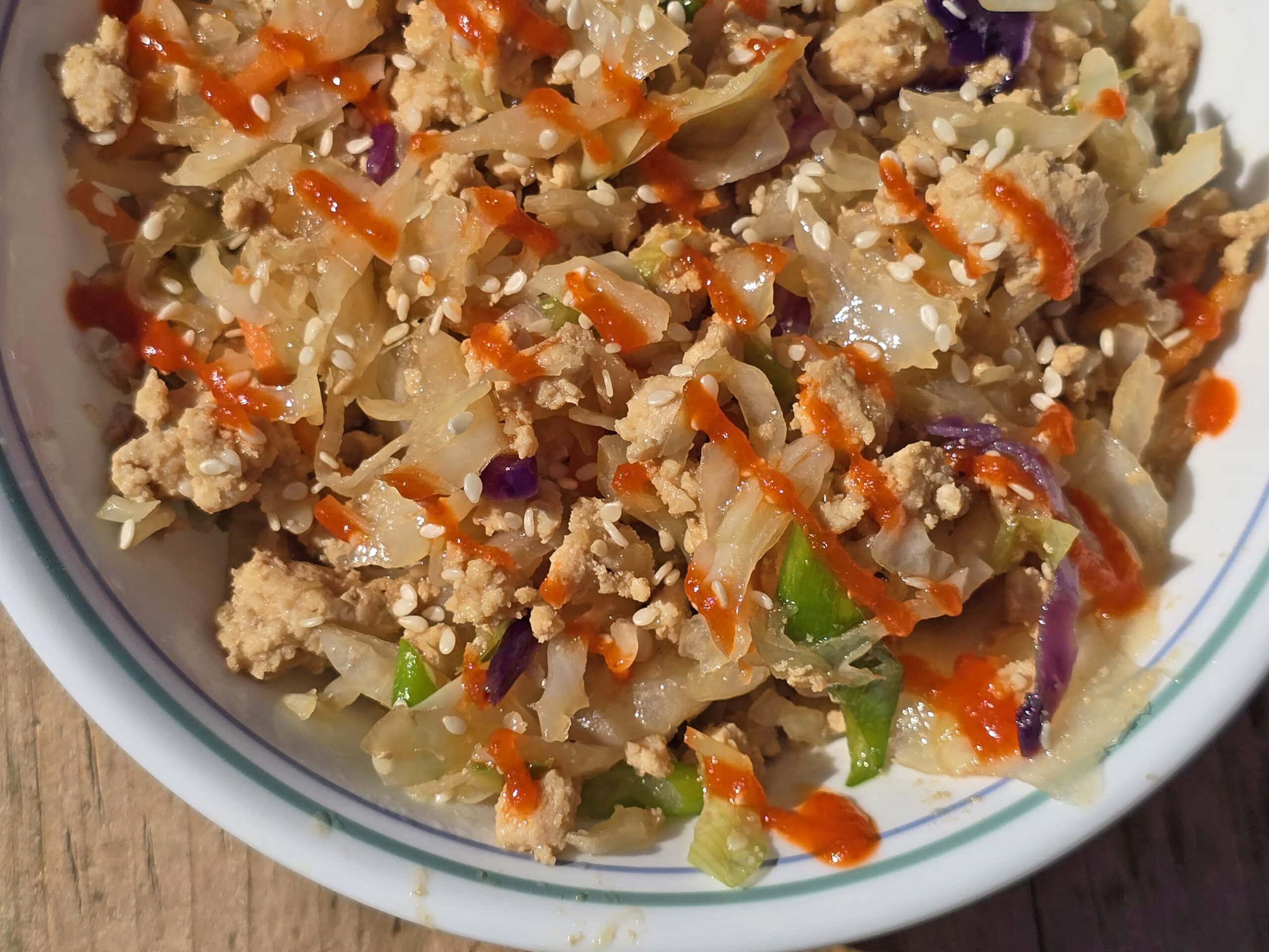 A bowl of egg roll in a bowl - shredded cabbage, ground beef, and more.