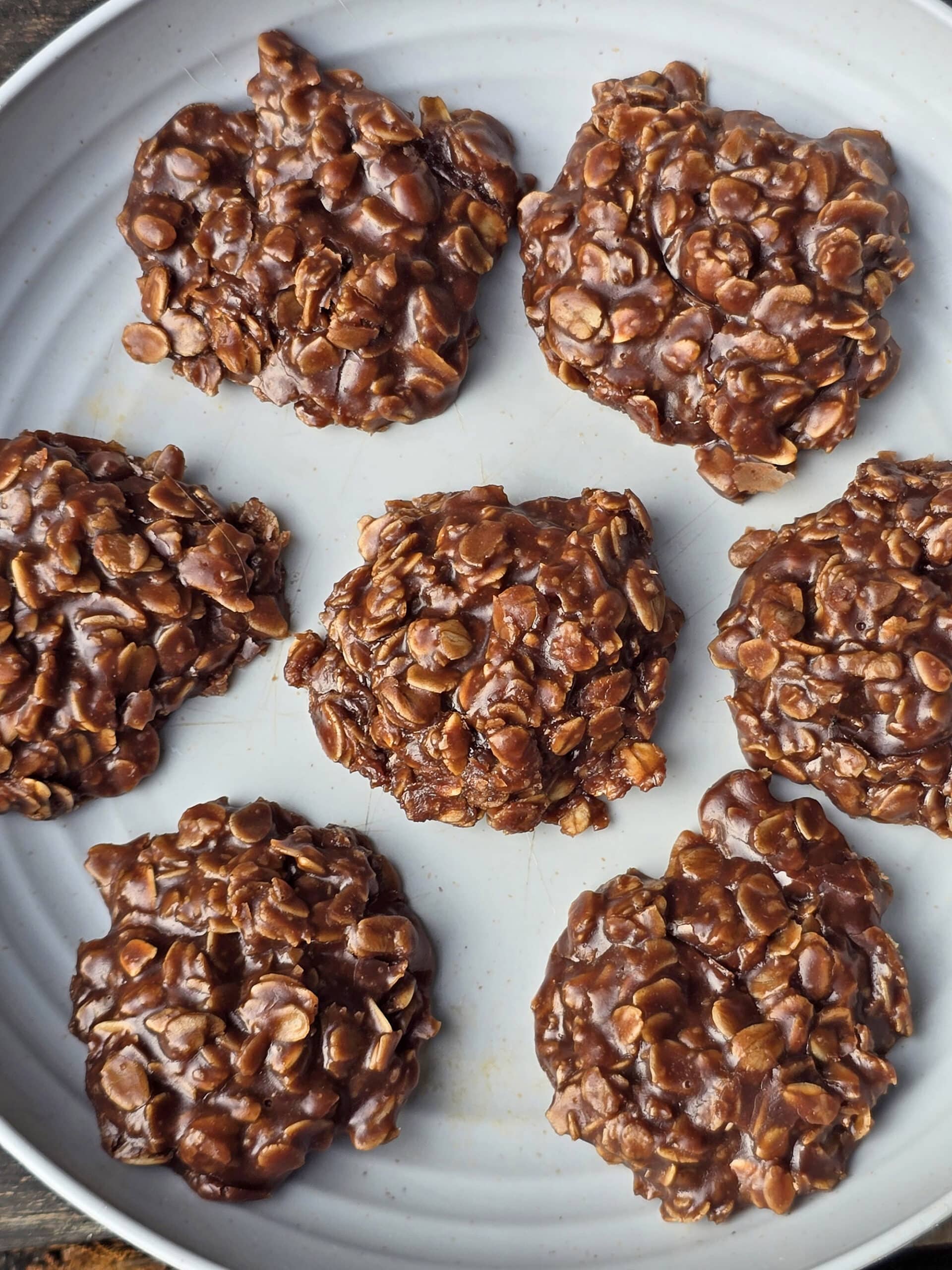 A plate of no bake chocolate peanut butter cookies with oats.