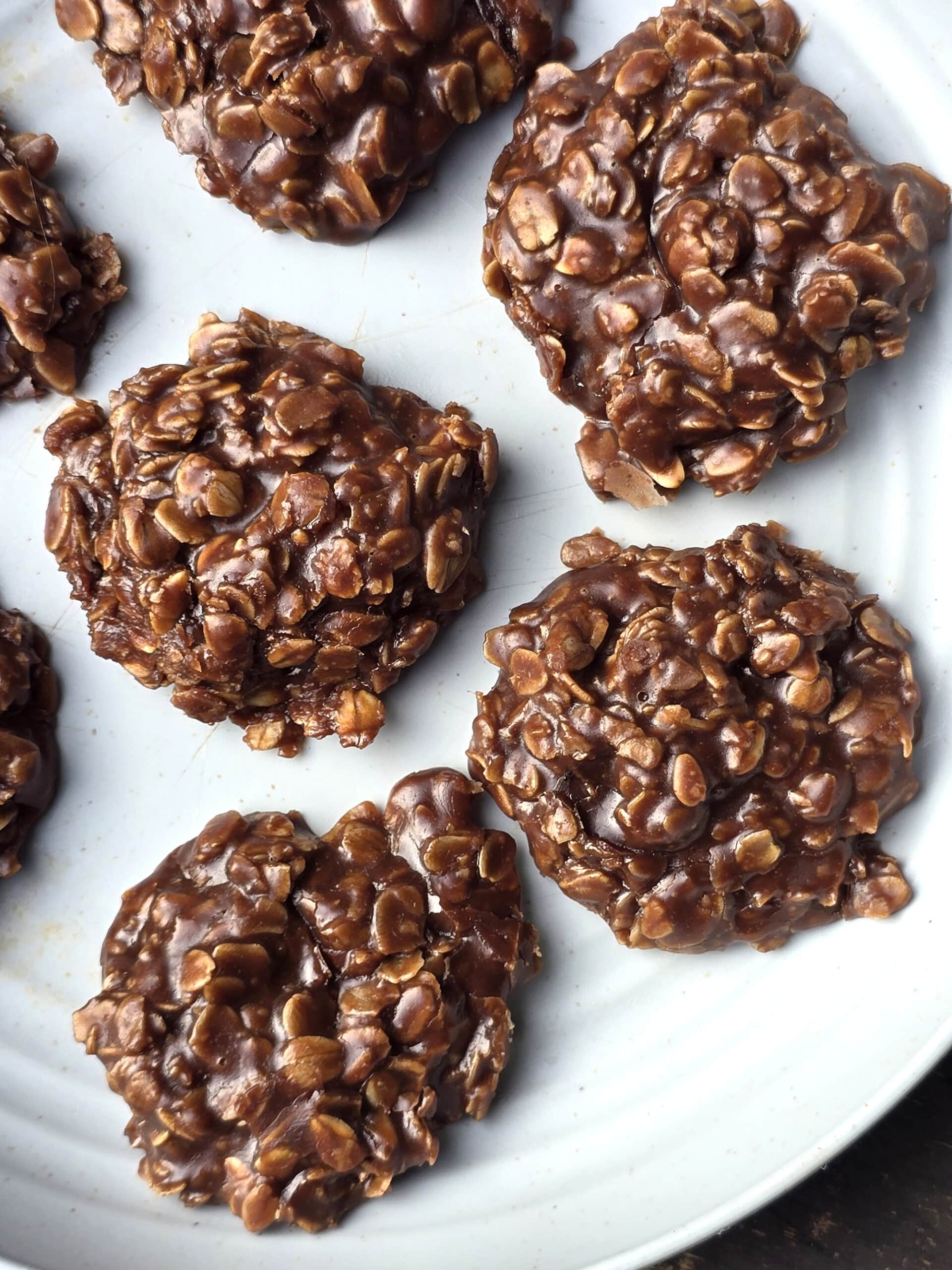 A plate of no bake chocolate peanut butter cookies with oats.