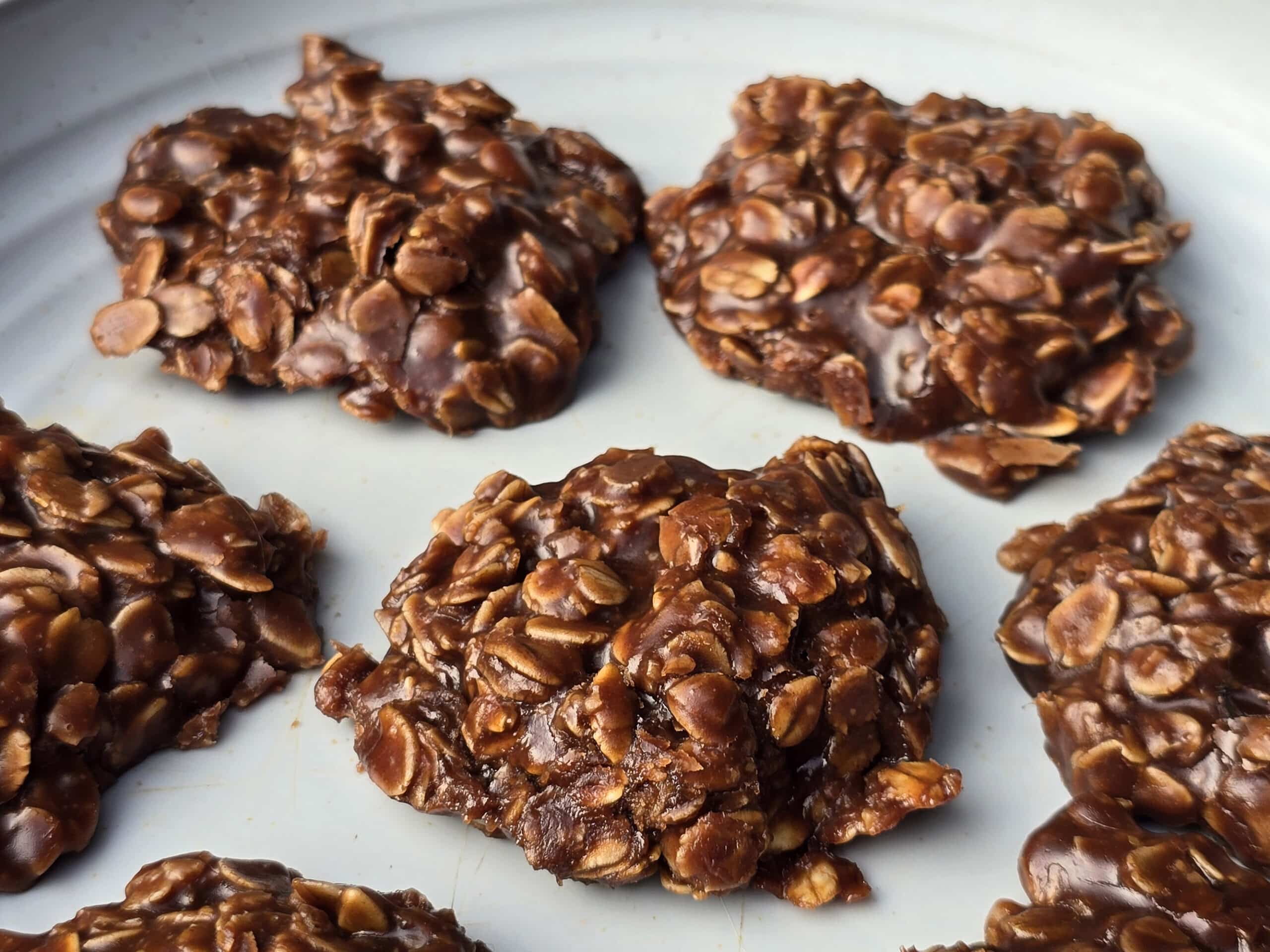 A plate of no bake chocolate peanut butter cookies with oats.