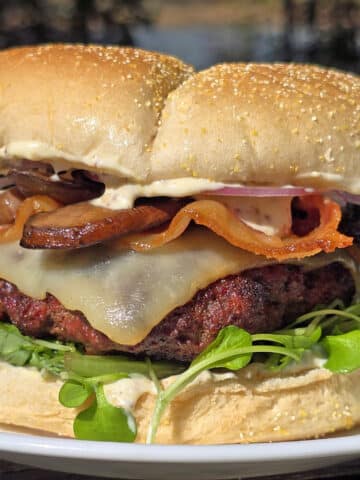 A loaded elk burger with bacon, smoked cheddar, sauteed mushrooms, and dijonnaise.
