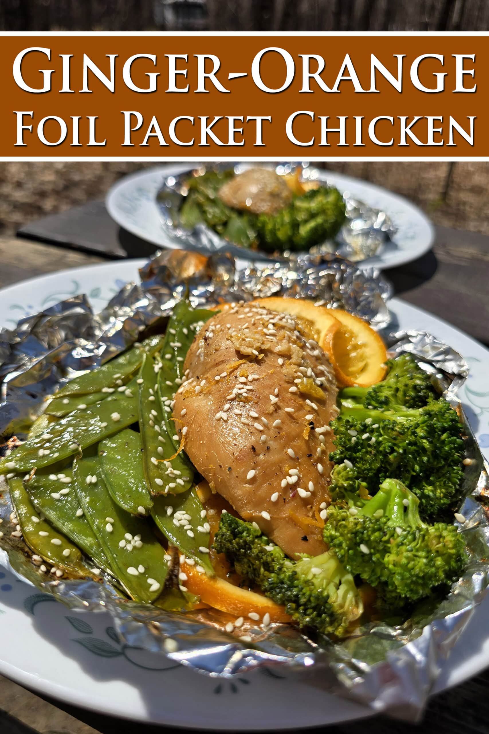 2 portions of orange ginger chicken in foil packets, with broccoli and peas.  Overlaid text says ginger orange foil packet chicken.