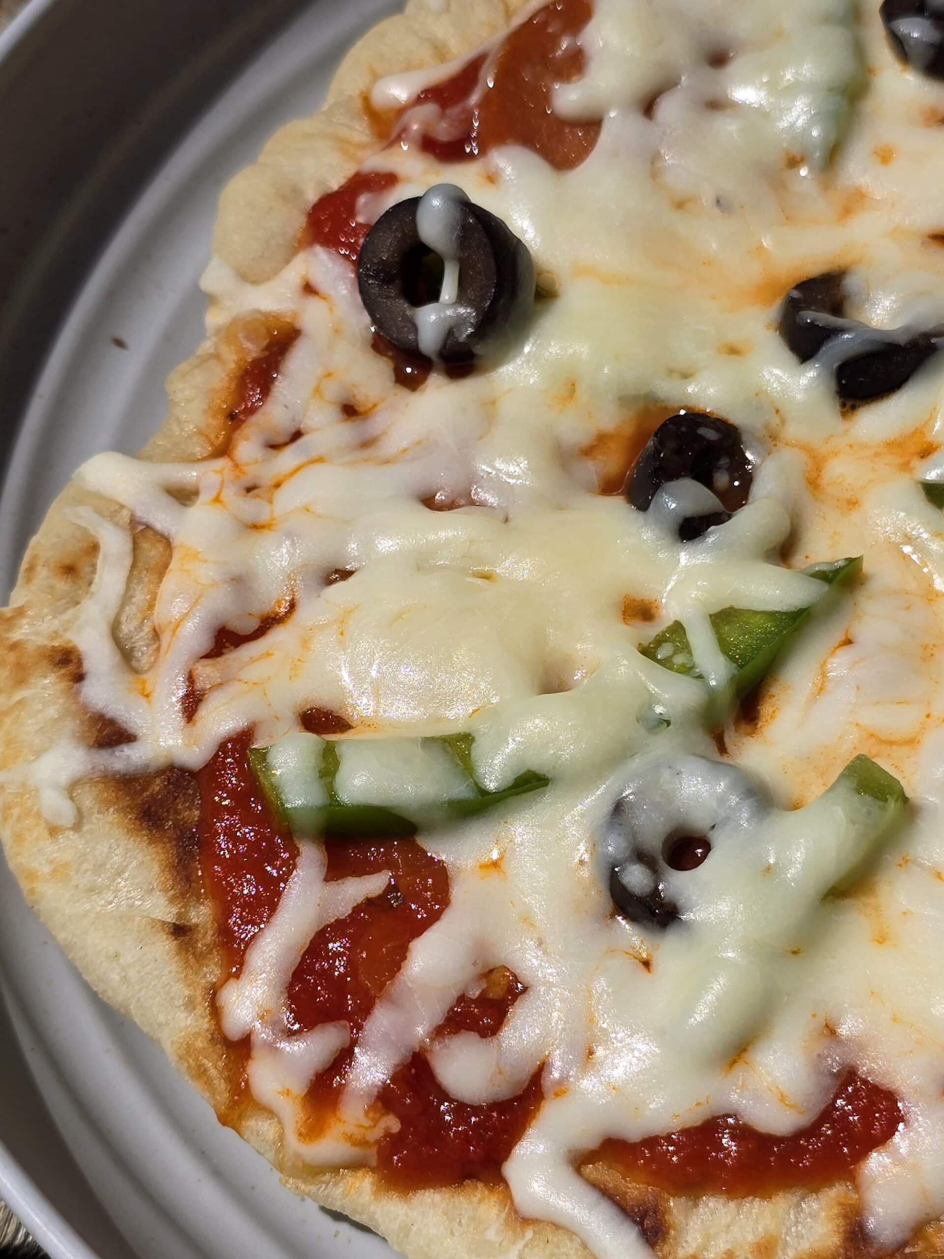 An individual camping pizza on a plate.