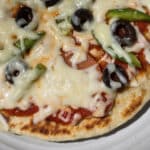 An individual camping pizza on a plate.