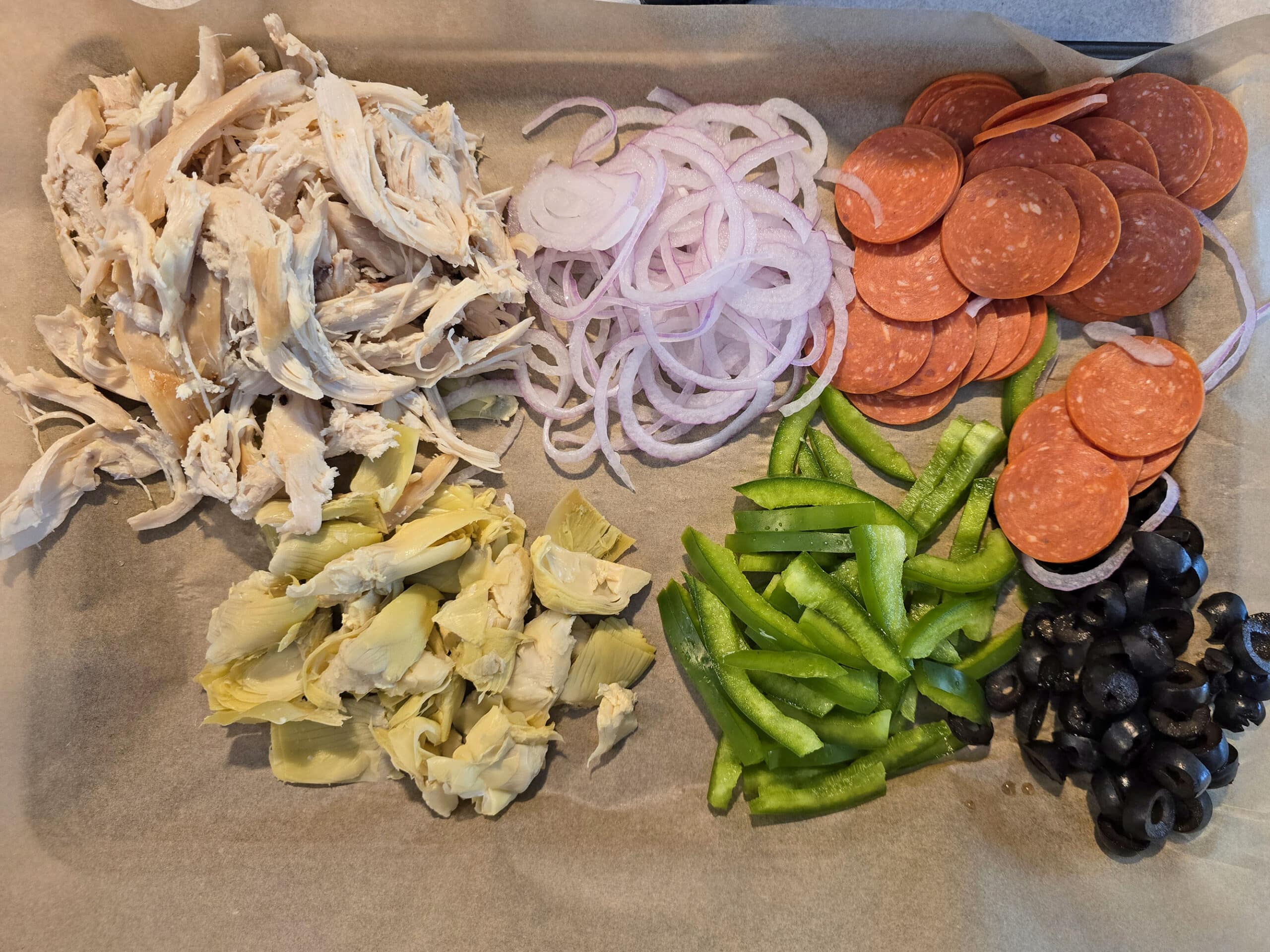 A tray of prepared pizza toppings.