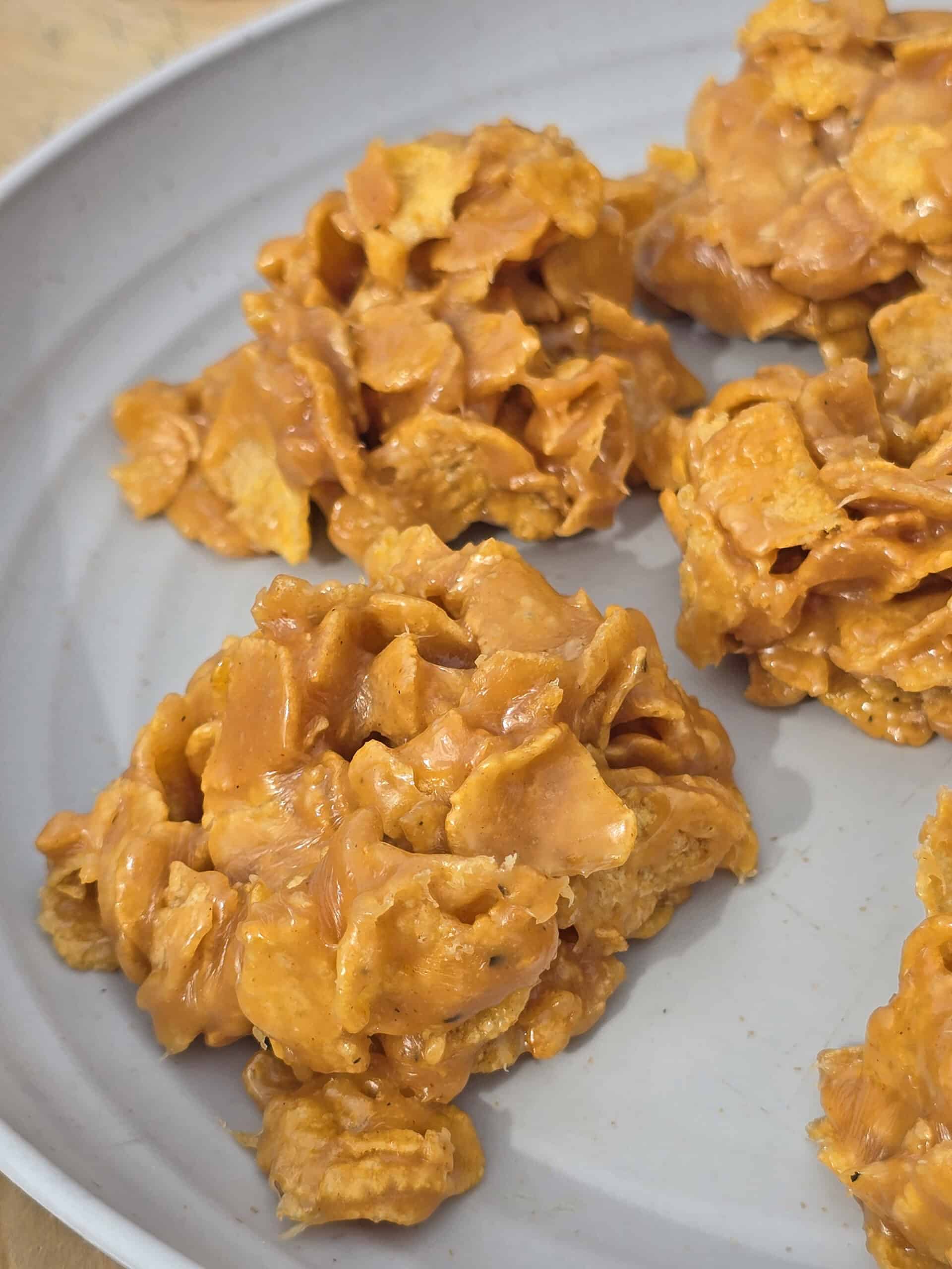 A plate of no bake peanut butter corn flake cookies on a picnic table.