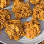 A plate of no bake cornflake cookies on a picnic table.