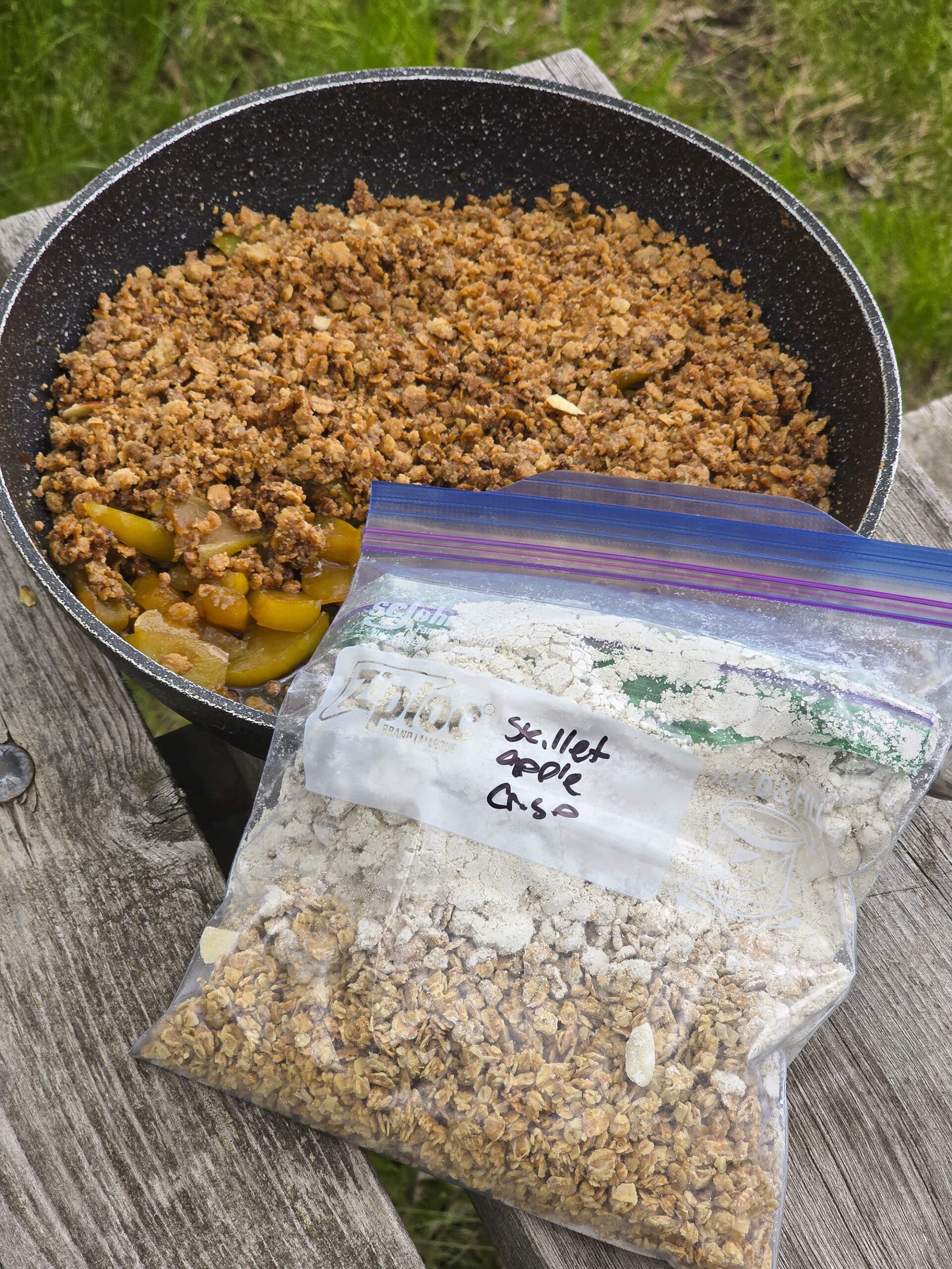 A pan of skillet apple crisp with a  bag of apple crisp topping mix.
