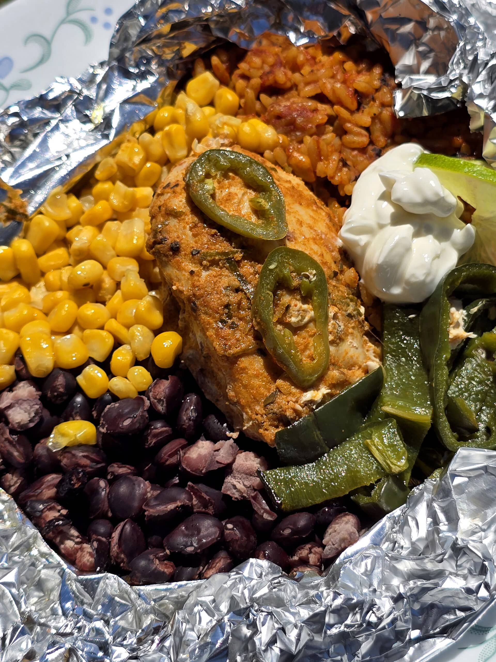 A Southwest Chicken foil packet, with Southwest marinated chicken, black beans, corn, Mexican rice, and poblano peppers.