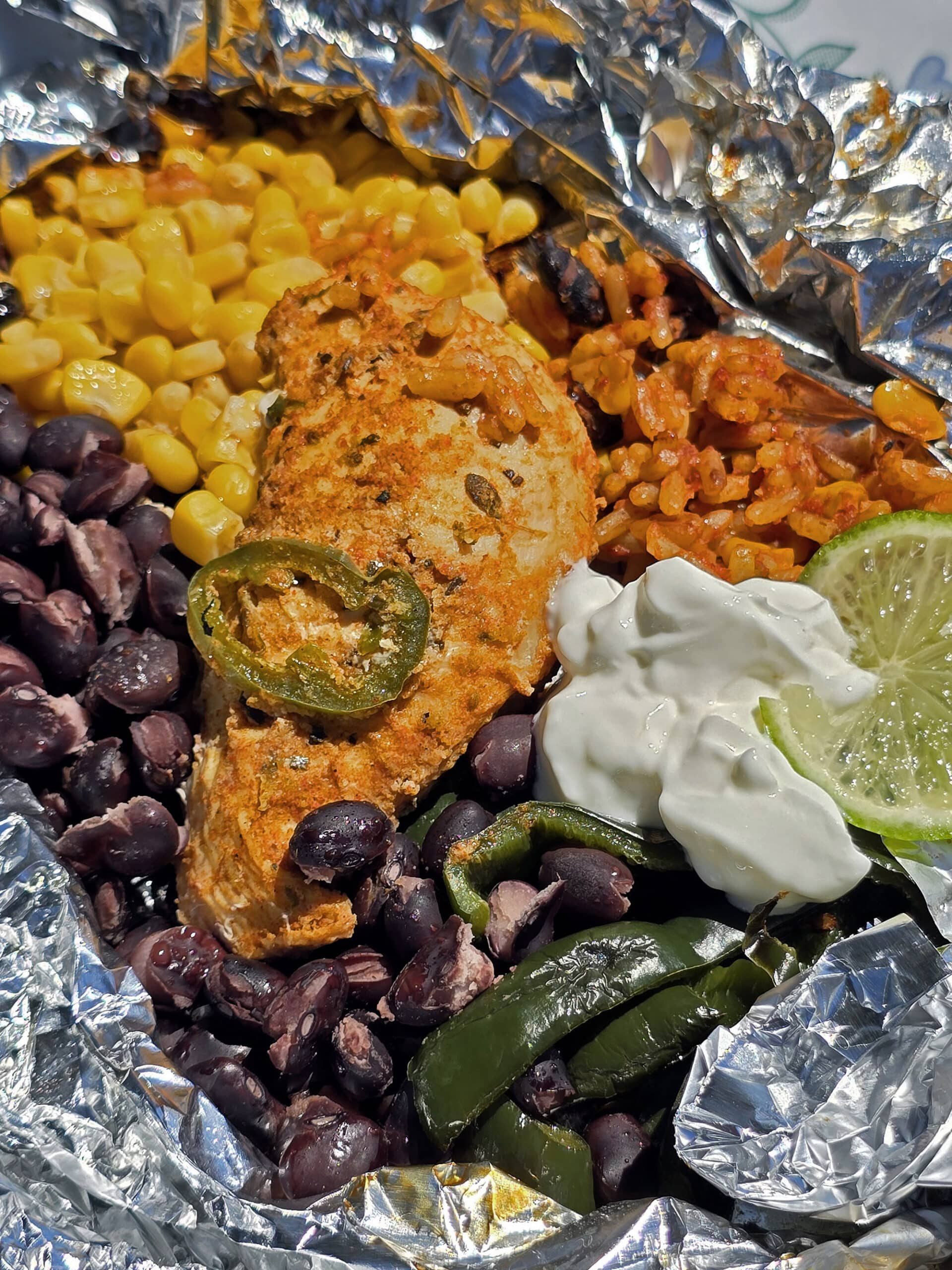 A Southwest Chicken foil packet, with Southwest marinated chicken, black beans, corn, Mexican rice, and poblano peppers.