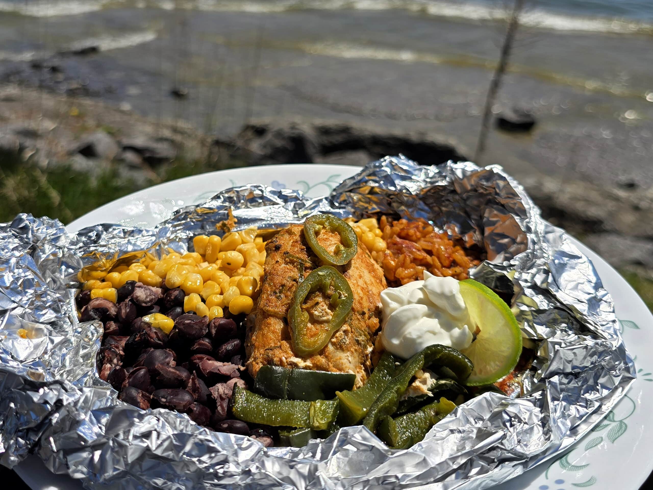 A Southwestern Chicken foil packet, with Southwest marinated chicken, black beans, corn, Mexican rice, and poblano peppers.