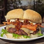 A venison burger with smoked cheddar, bacon, dijonnaise, and whiskey caramelized onions.