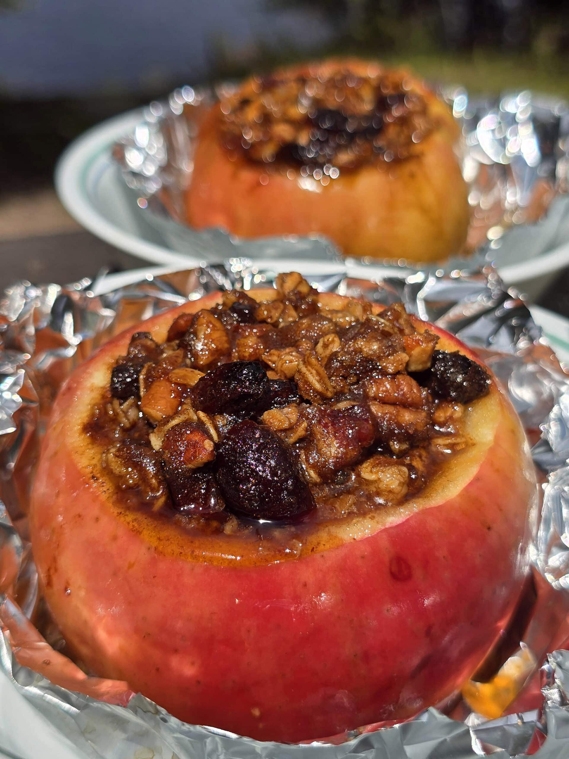 2 large campfire baked apples in foil, stuffed with granola, raisins, brown sugar, nuts, and cinnamon.