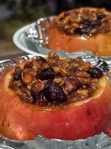 2 large campfire baked apples in foil, stuffed with granola, raisins, brown sugar, nuts, and cinnamon.