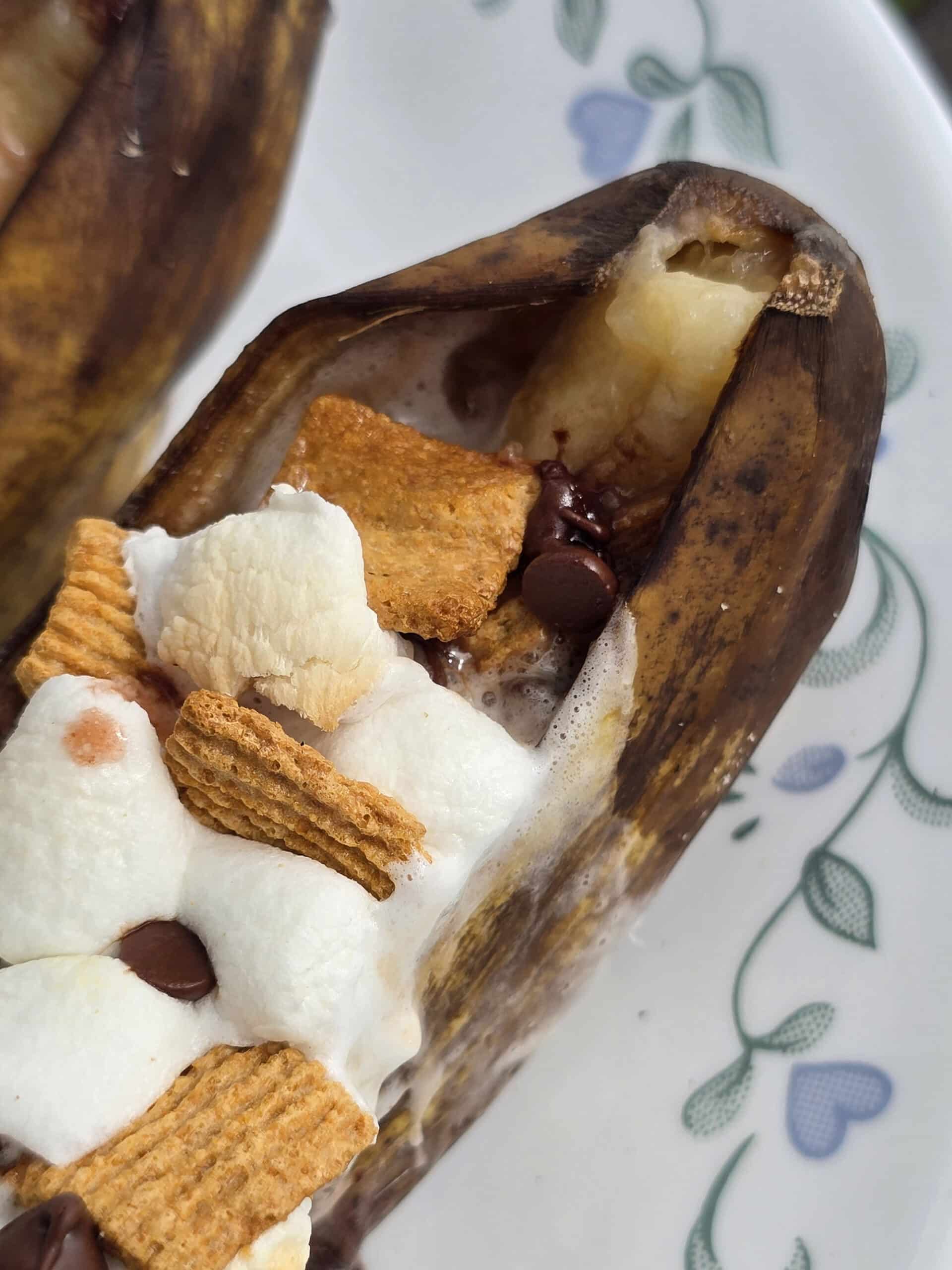 A campfire banana boat stuffed with marshmallows, chocolate chips, and golden grahams cereal.