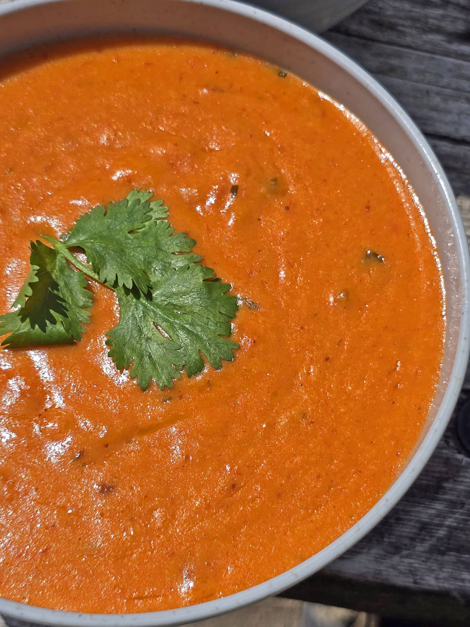 A bowl of Mexican cheese dip with cilantro on top.