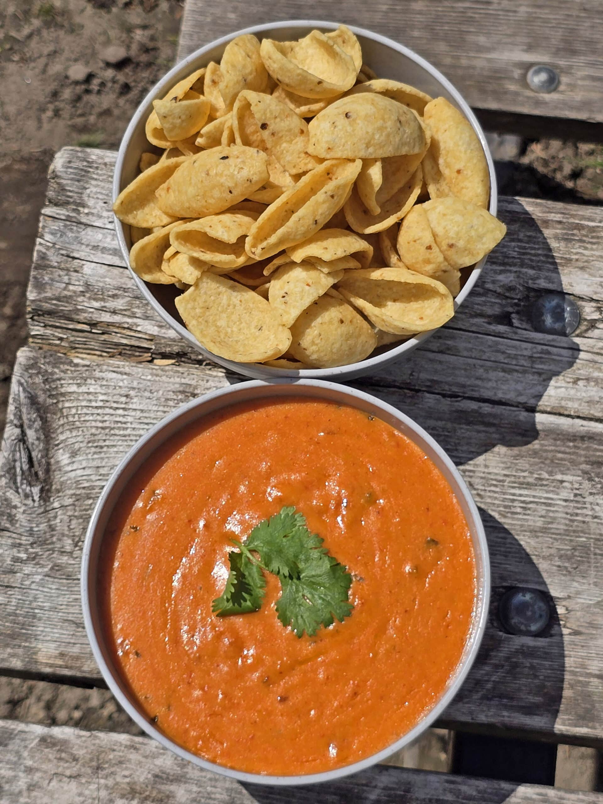 A bowl of hot cheddar queso dip with cilantro on top.