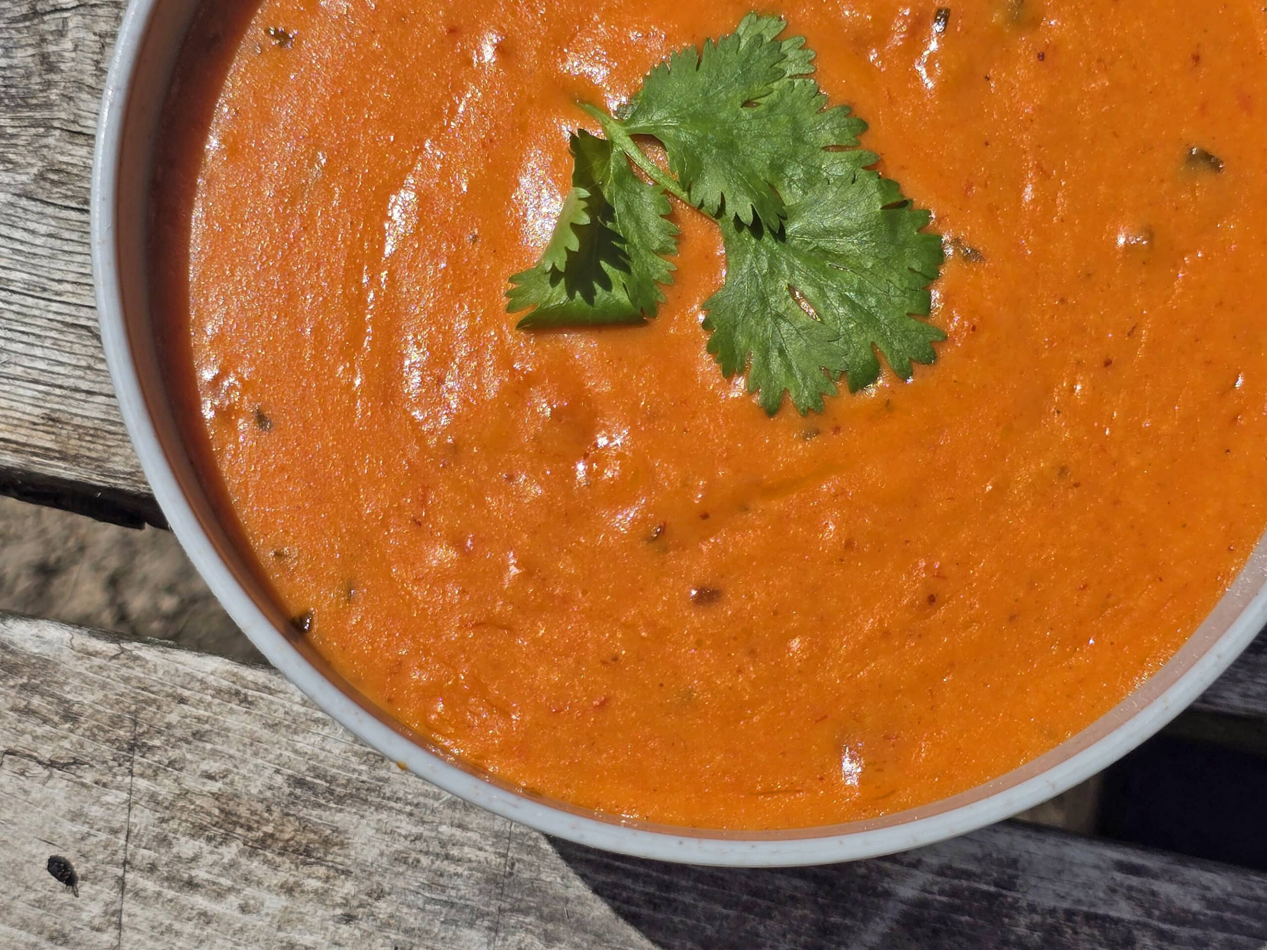 A bowl of Mexican cheese dip with cilantro on top.