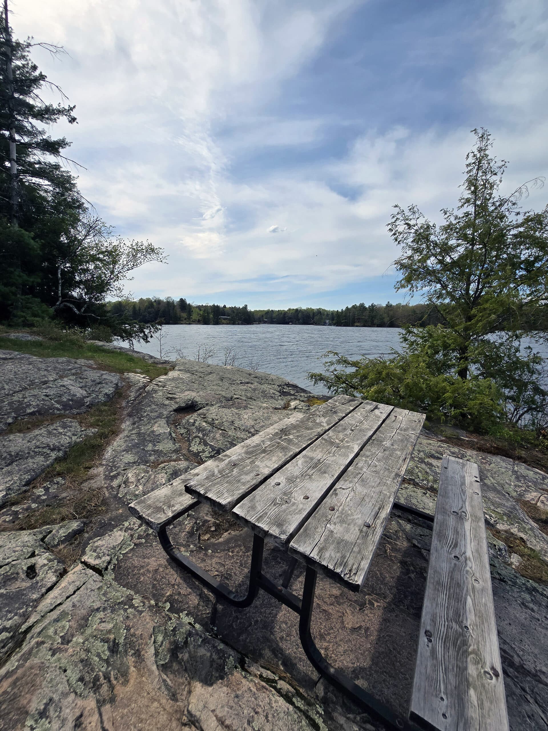 A picnic table on a rock overlooking oastler lake.