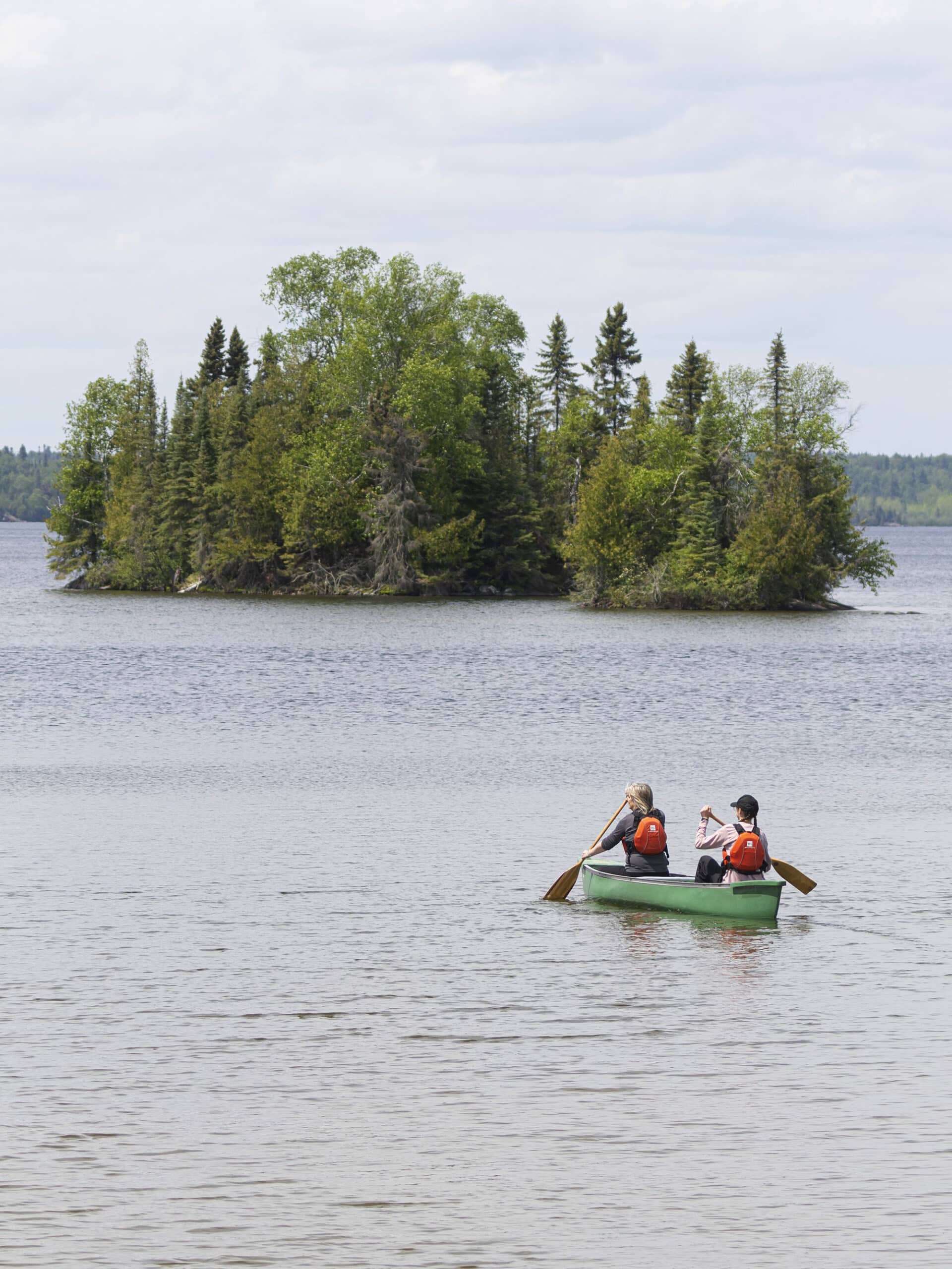 2 people in a canoe on thunder lake, with an island in the distance.