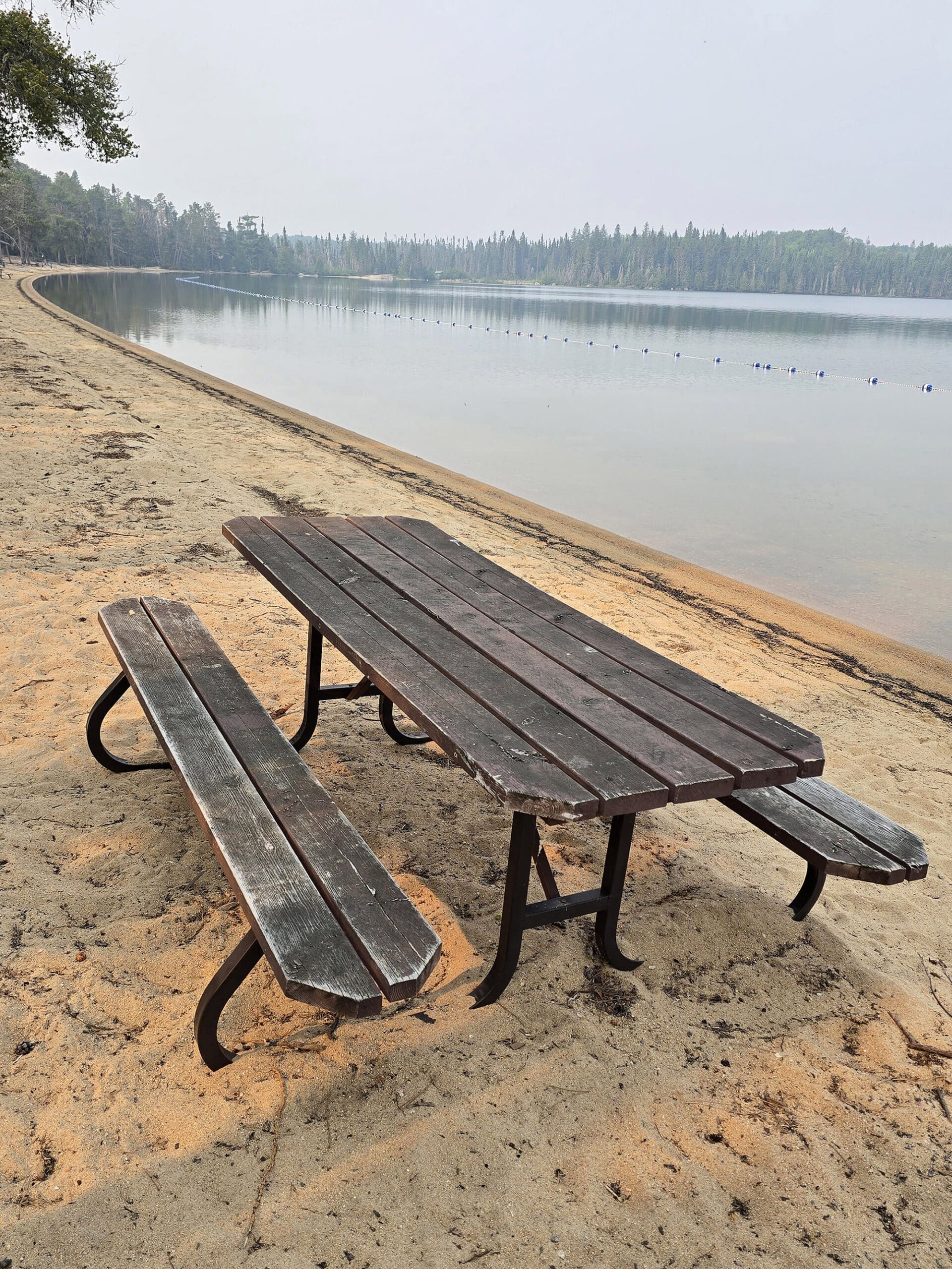 A picnic table on the beach alongside Blue Lake.