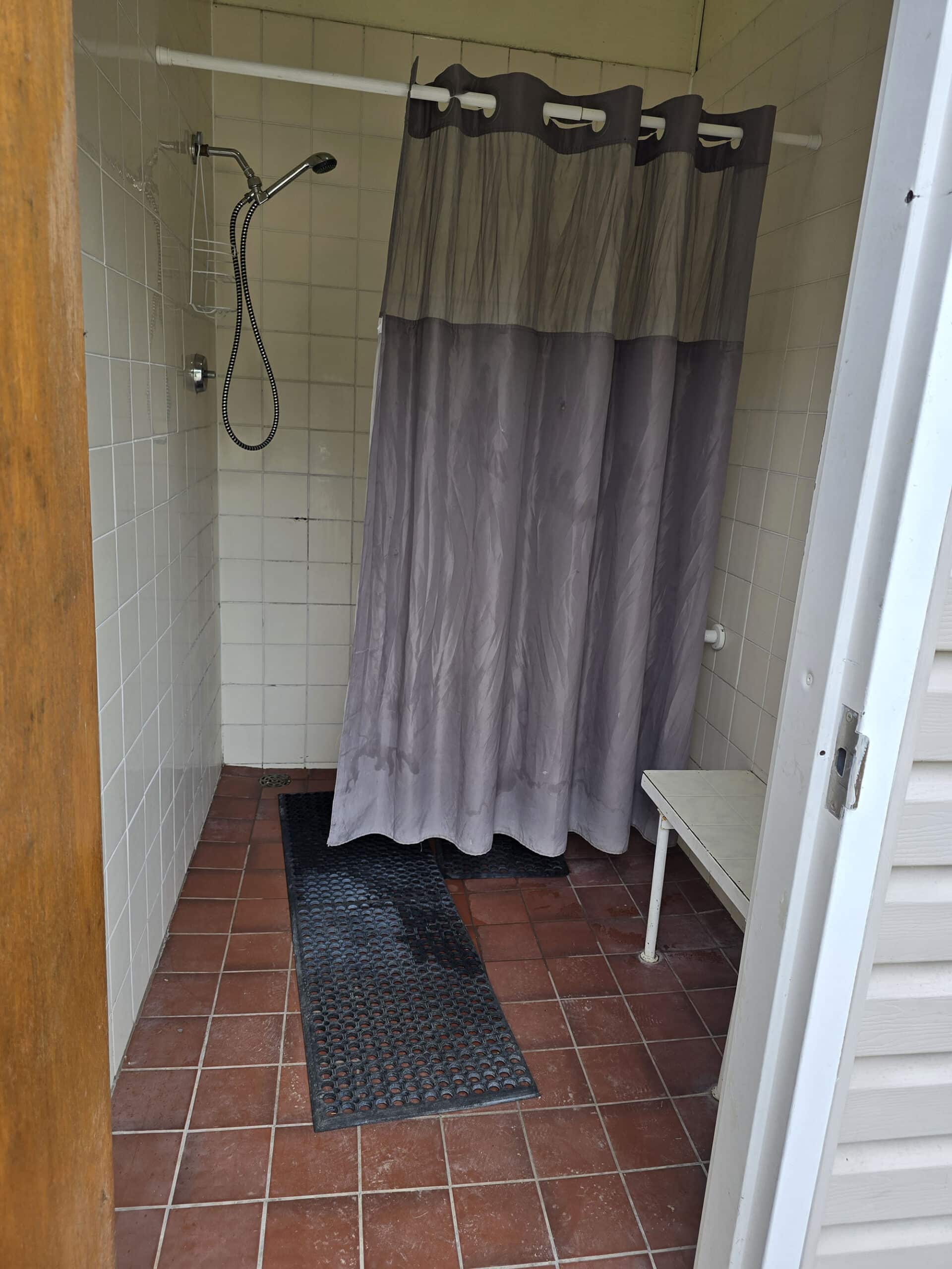 A comfort station shower stall with shower head installed high.