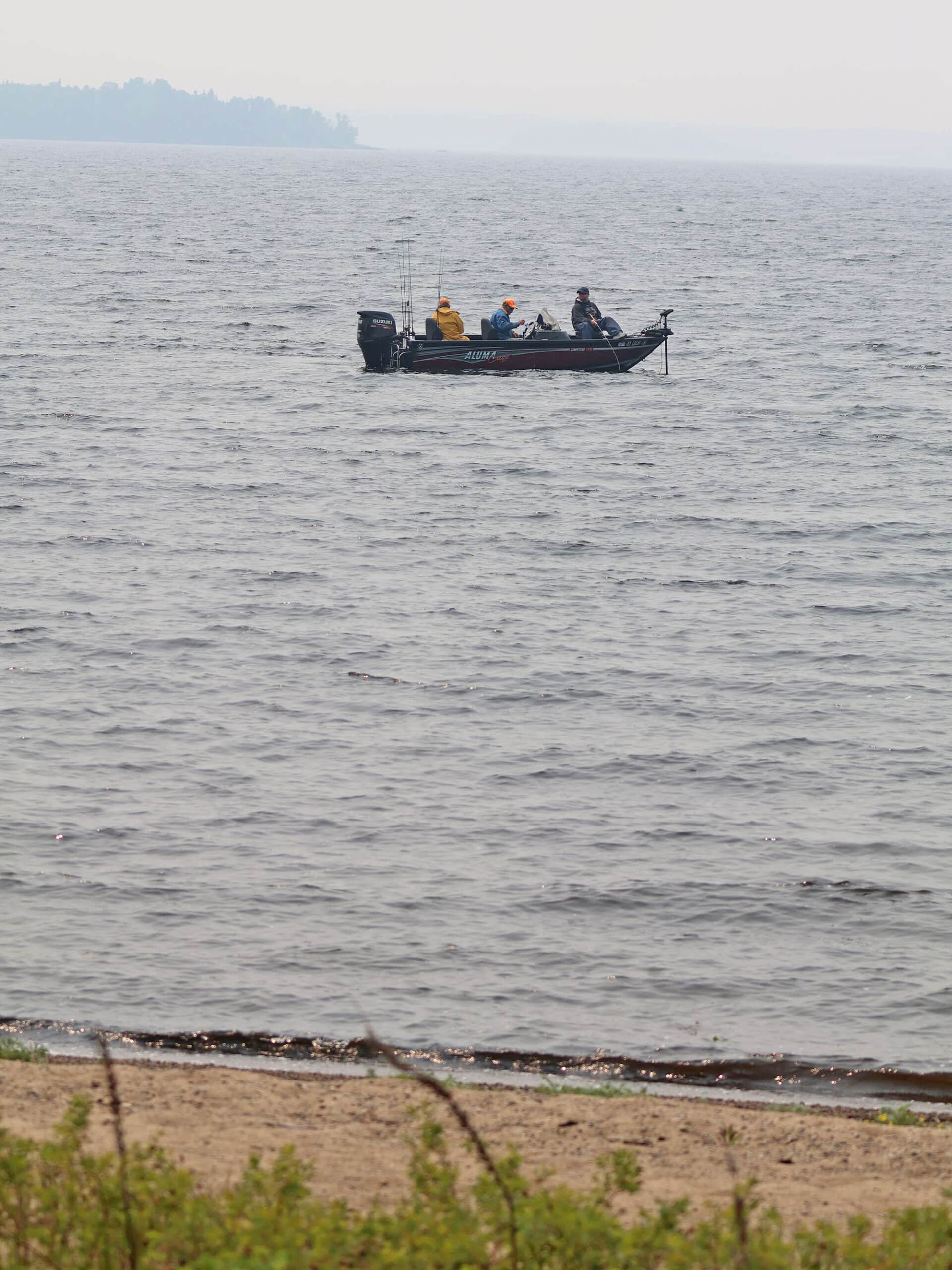 Several people fishing from a boat at Pakwash Provincial Park.