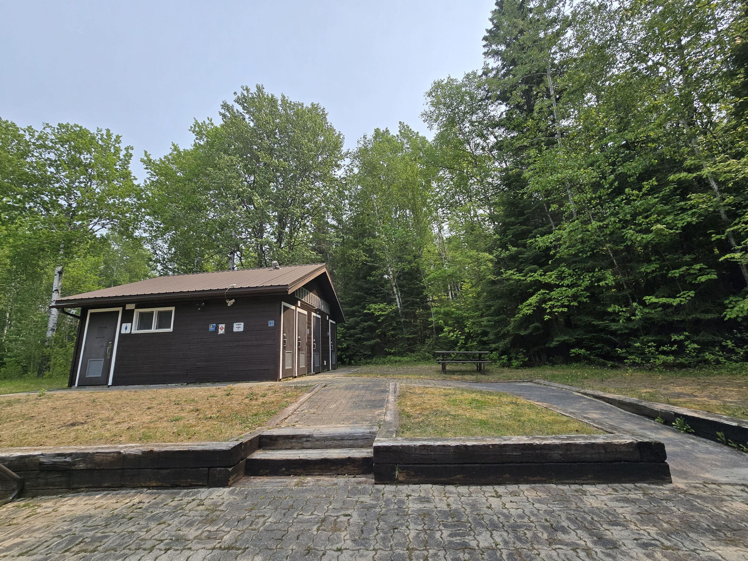 A side view of the Pakwash Provincial Park comfort station, with a ramp up to it.