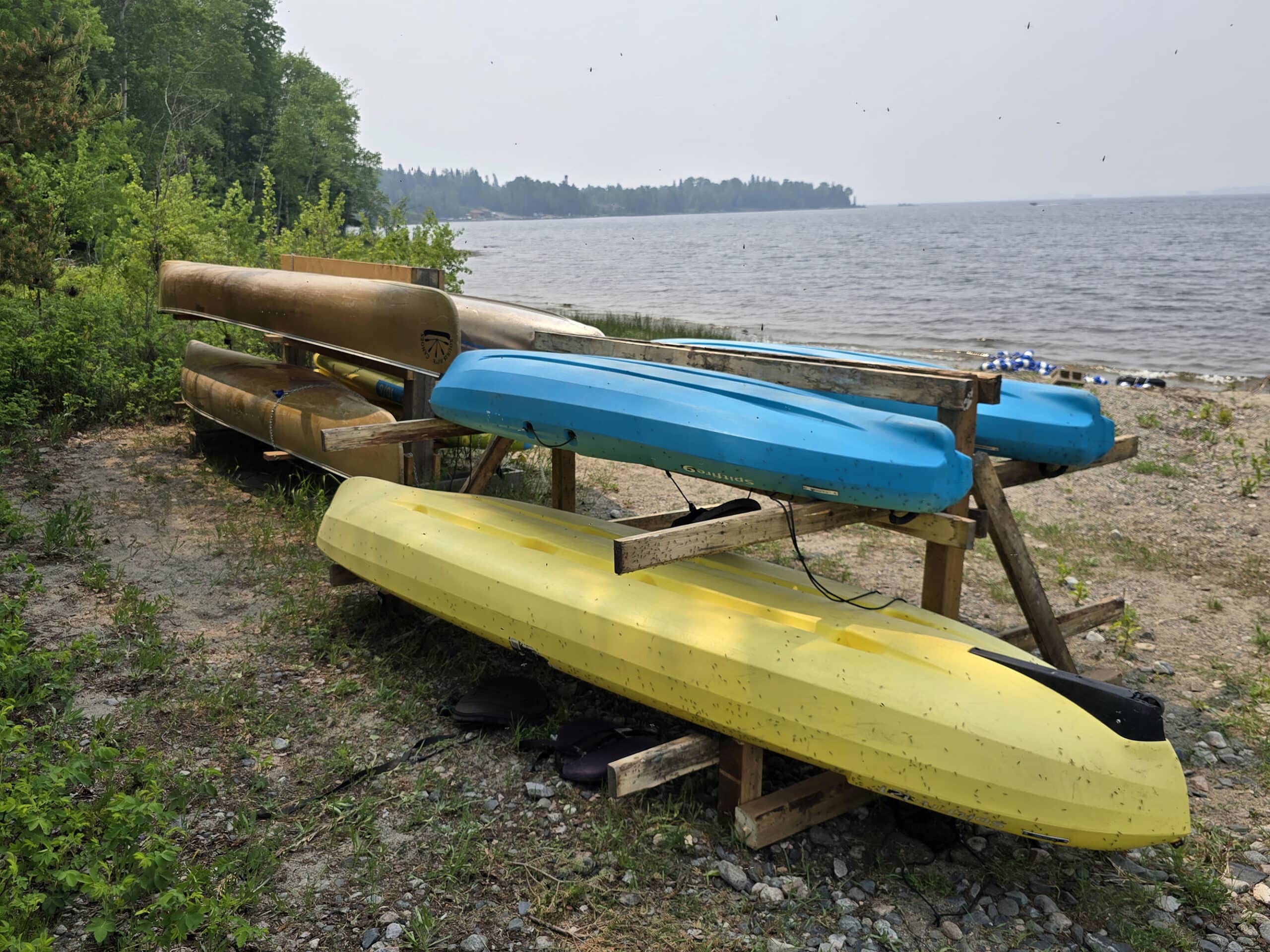 2 racks of canoes on the side of Pakwash Lake.
