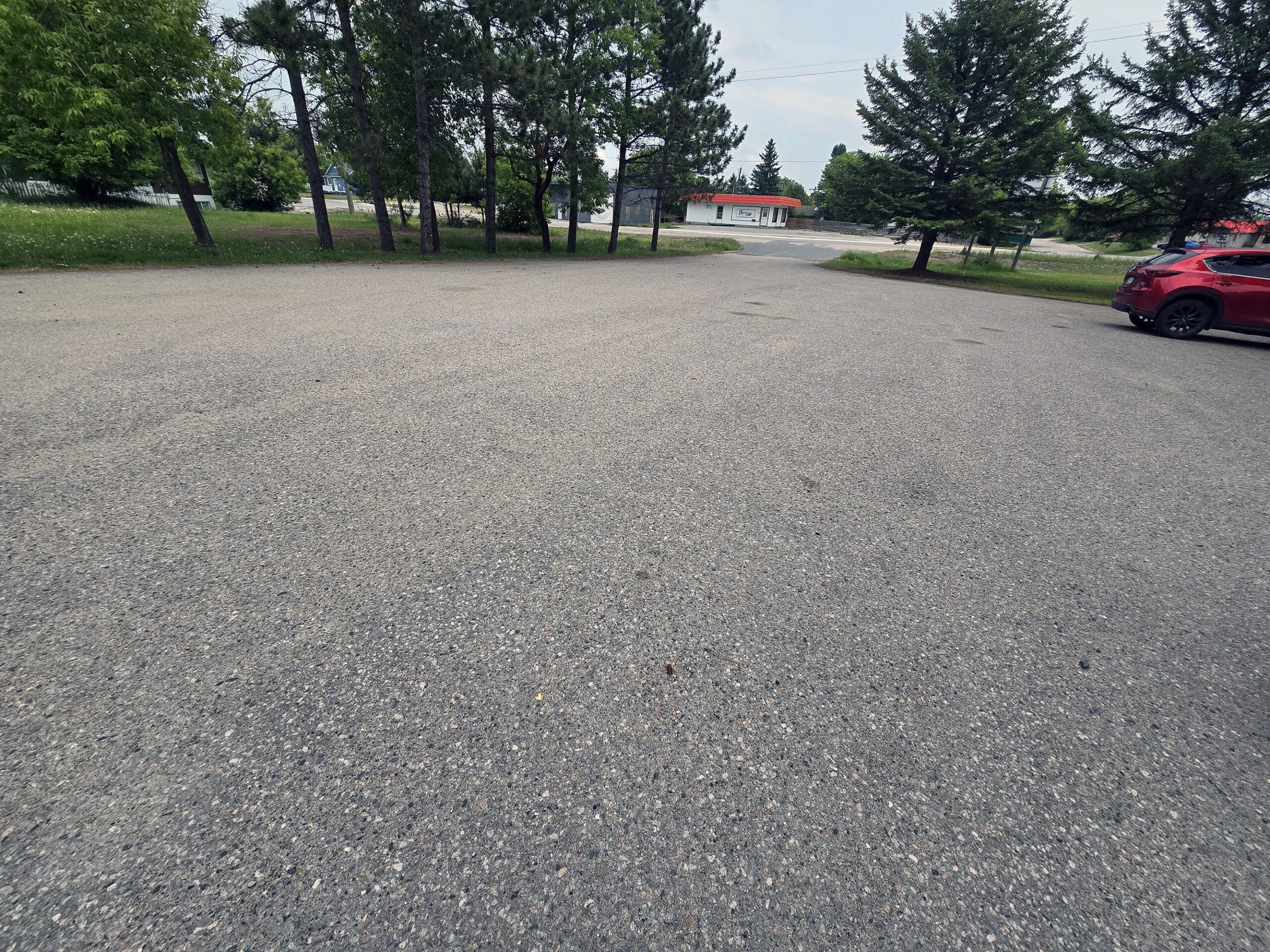 A small parking lot at Johnston Park and Roy Wilson Suspension bridge in dryden ontario.