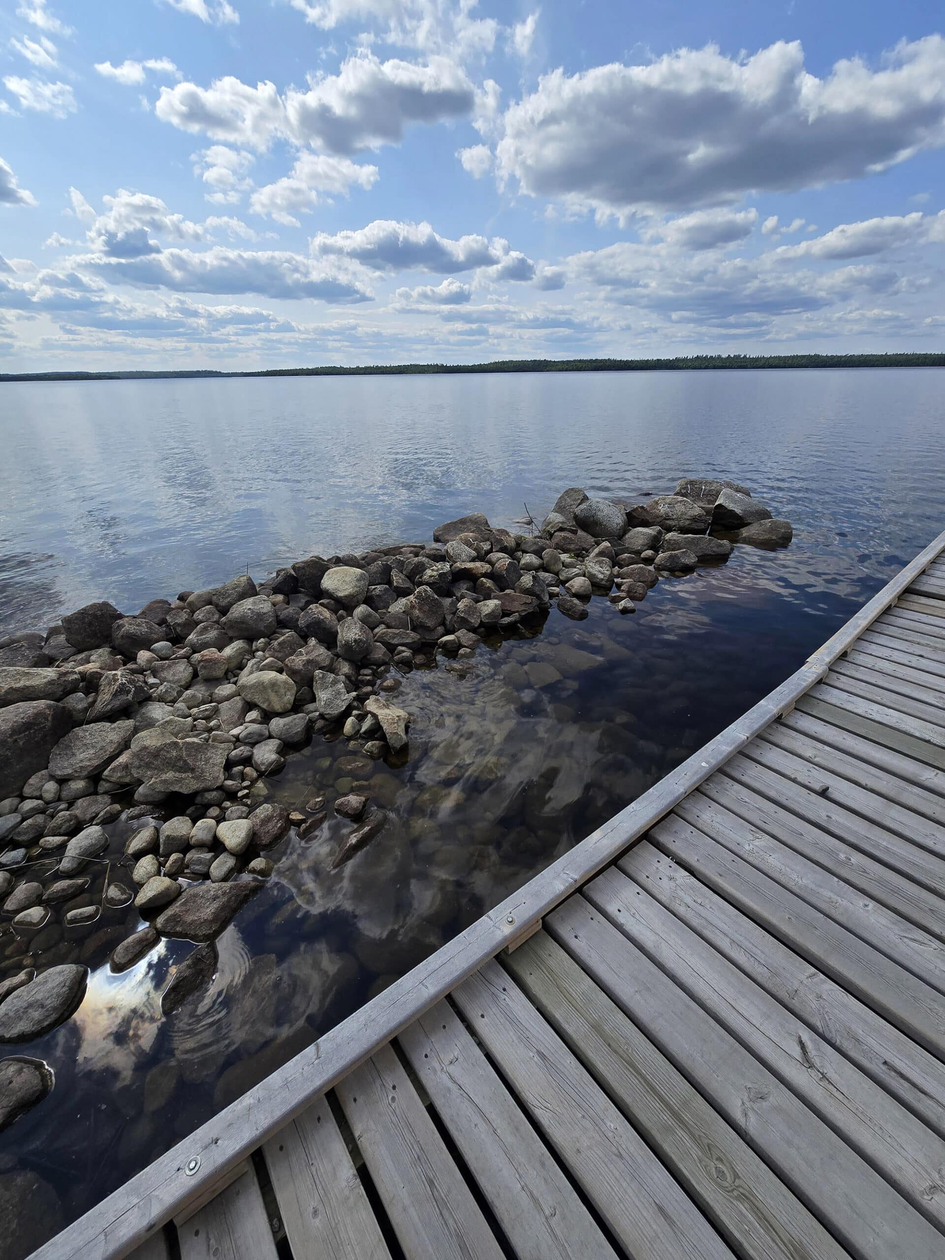 A rocky outcrop next to a wooden dock.