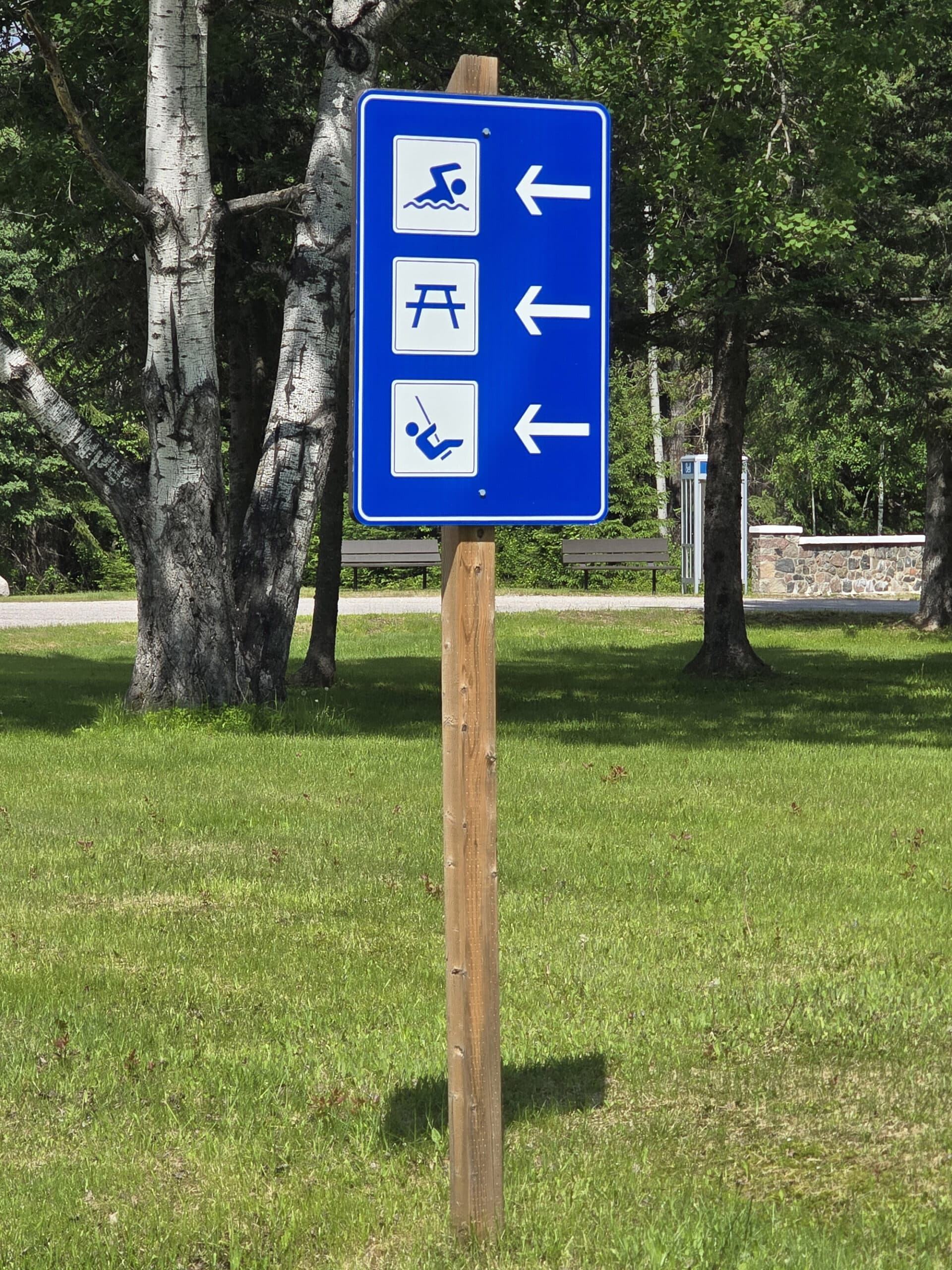 A blue and white campground road sign.