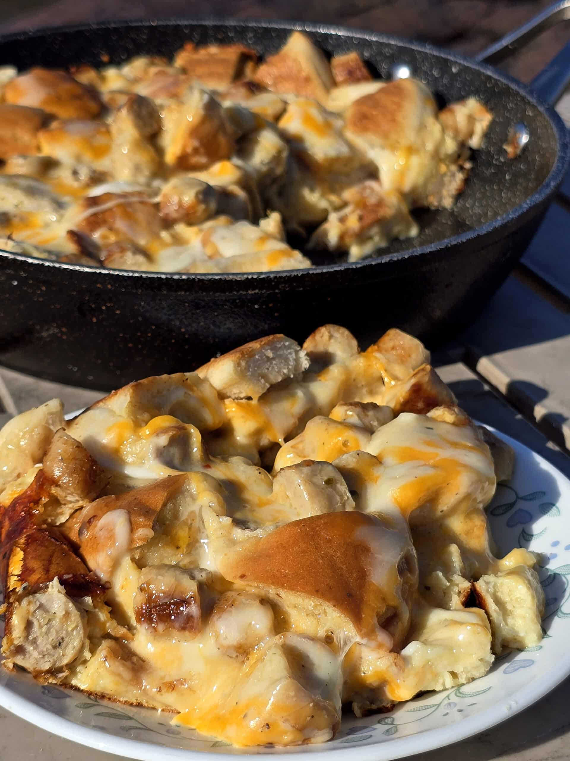 A pan and a plate of bagel breakfast casserole with sausage and cheese.