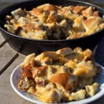A pan and a plate of bagel breakfast strata with sausage and cheese.