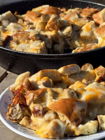 A pan and a plate of bagel breakfast strata with sausage and cheese.
