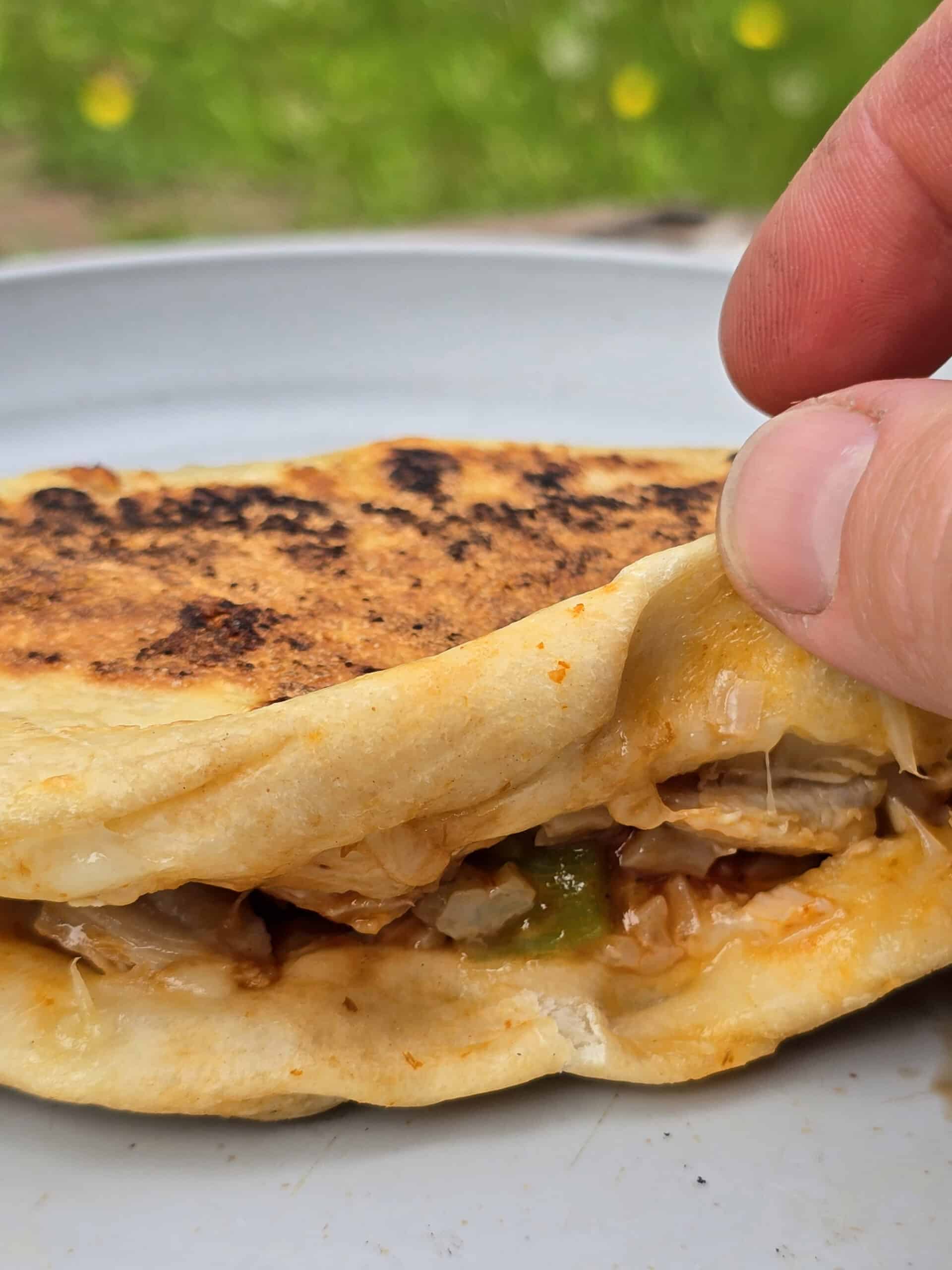 A hand opening a campfire calzone.