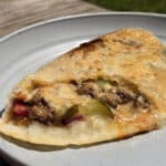 A grilled calzone stuffed with cheeseburger ingredients.