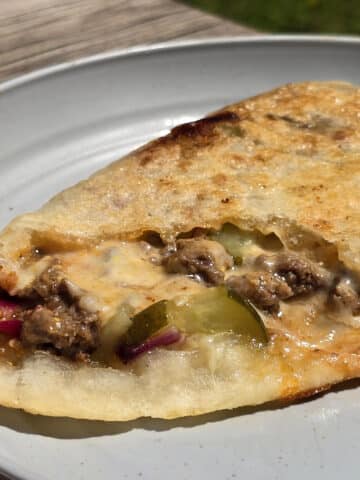 A grilled calzone stuffed with cheeseburger ingredients.
