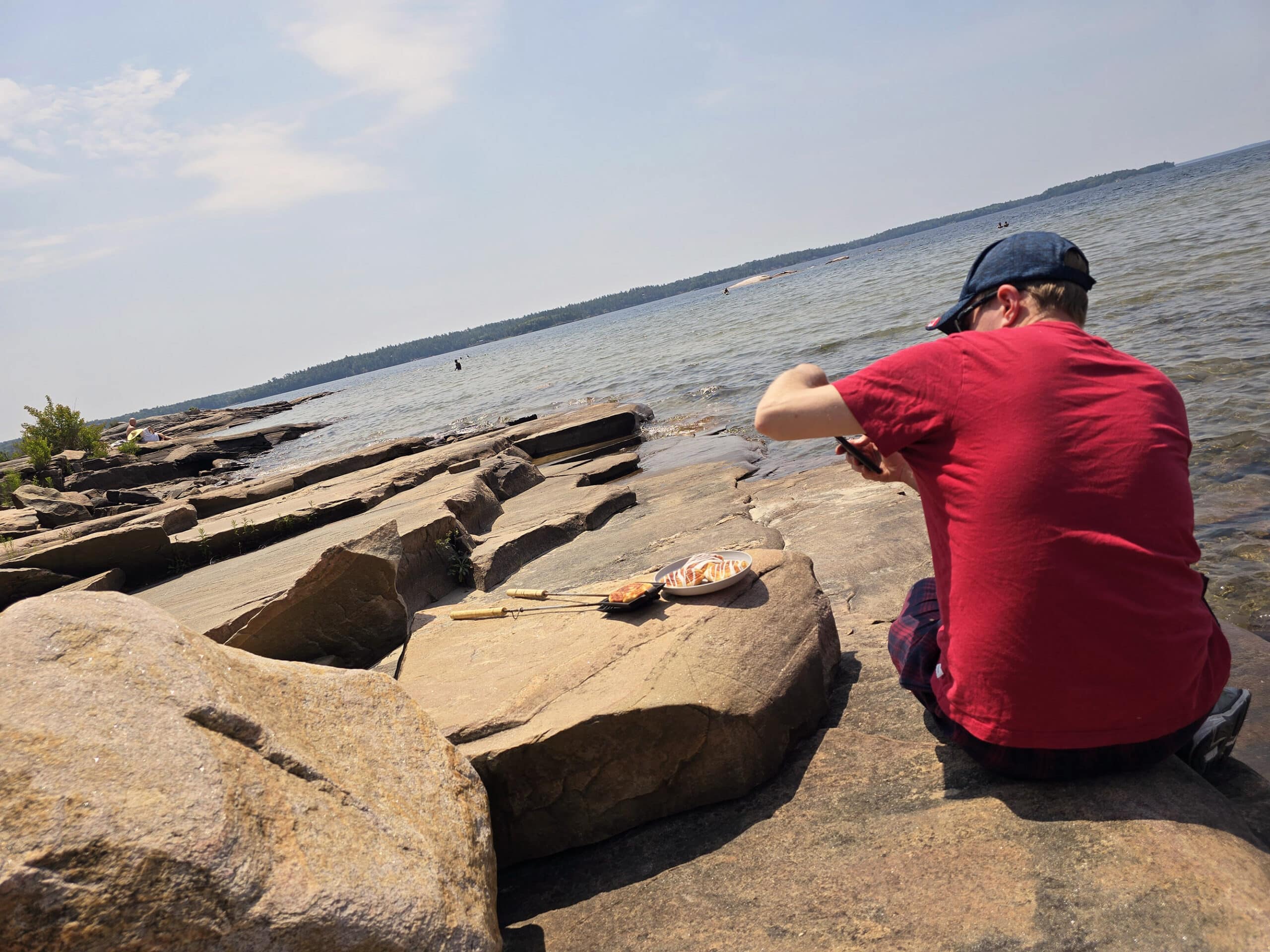 A man photographing pie iron cinnamon rolls at Killbear Provincial Park.