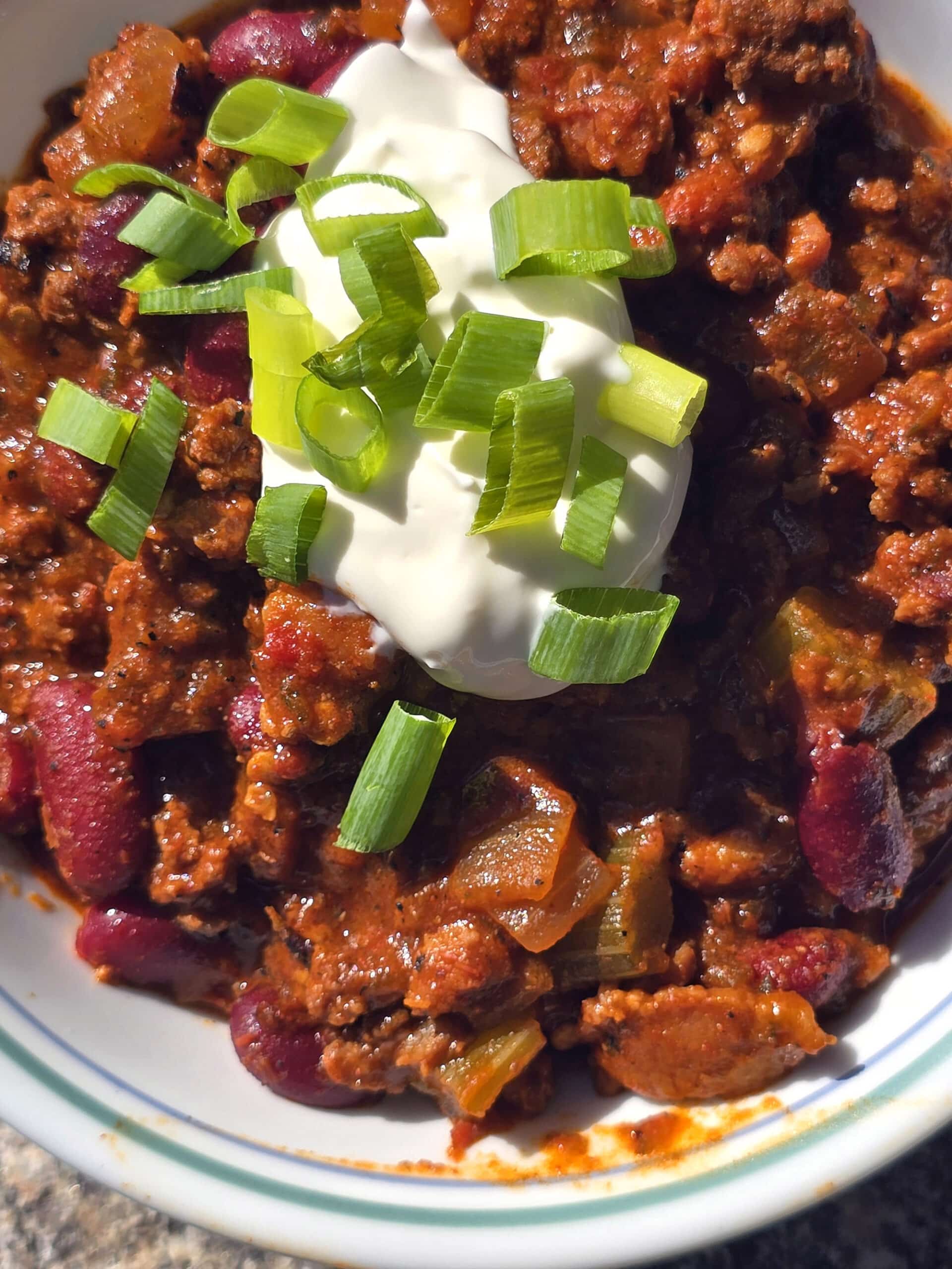 A bowl of smoky venison chili with beans and chunky vegetables visible.