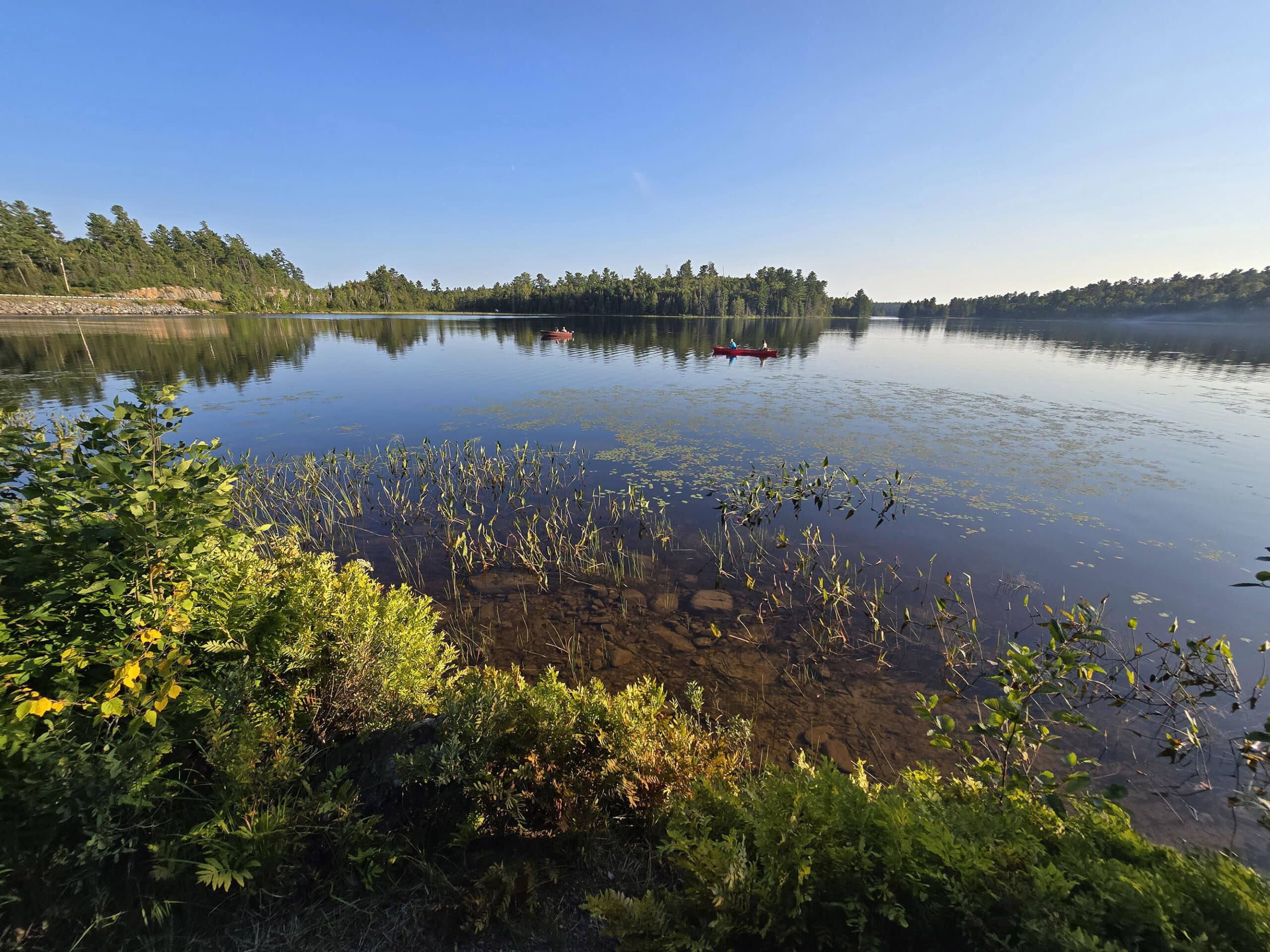 Kayakers on a calm Marten River, on a sunny day.