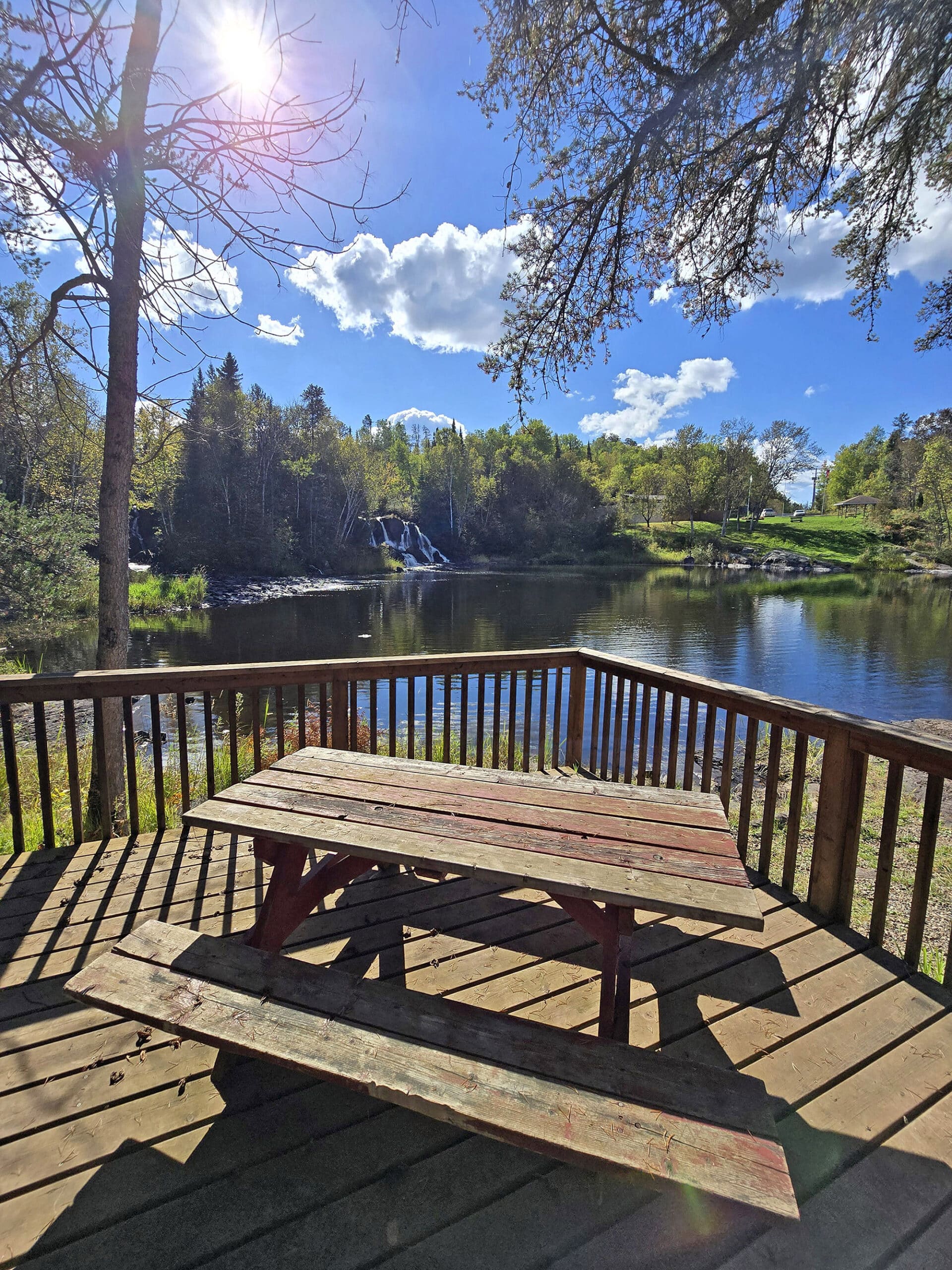 A picnic table and lookout platform, with Little Falls waterfall in the background.