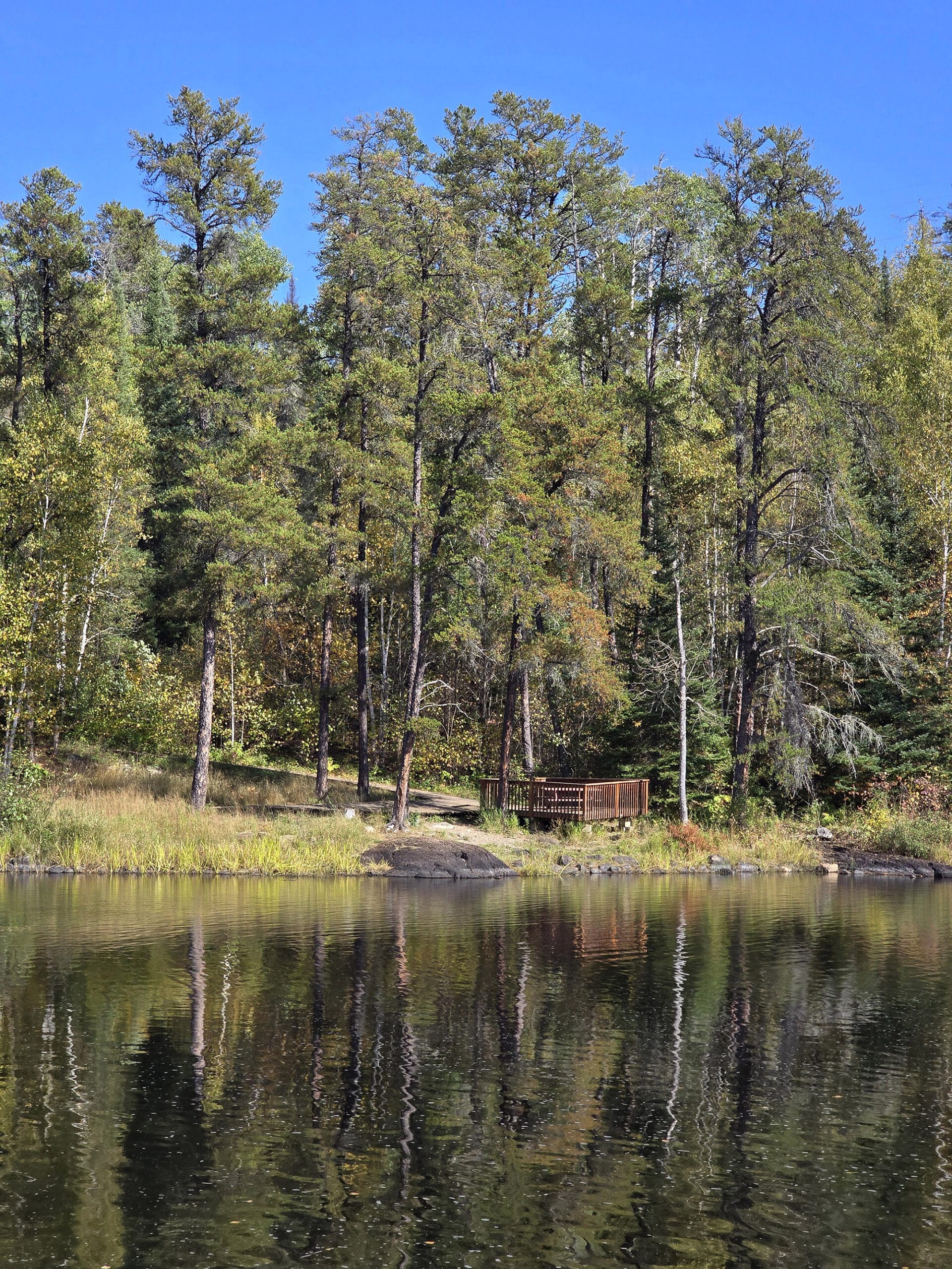 A view across a lake to a viewing platform.