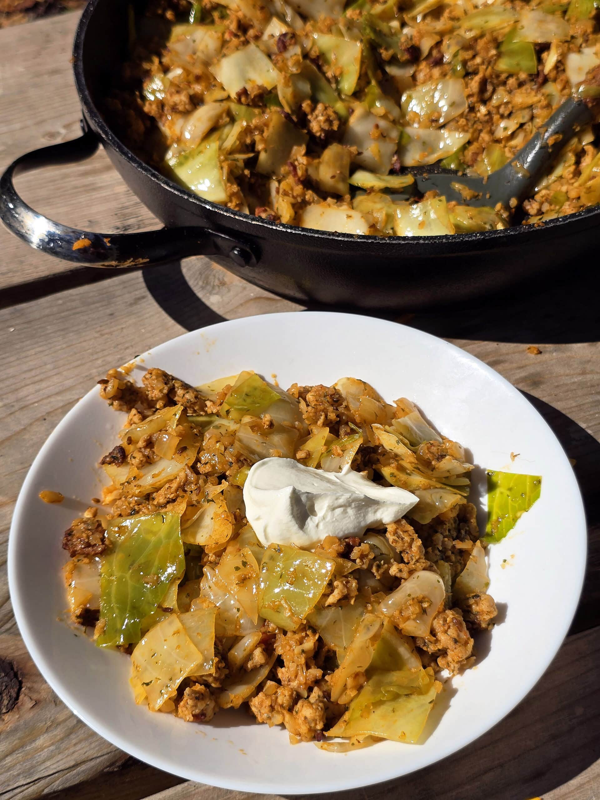A pan and bowl of lazy cabbage roll stir fry.