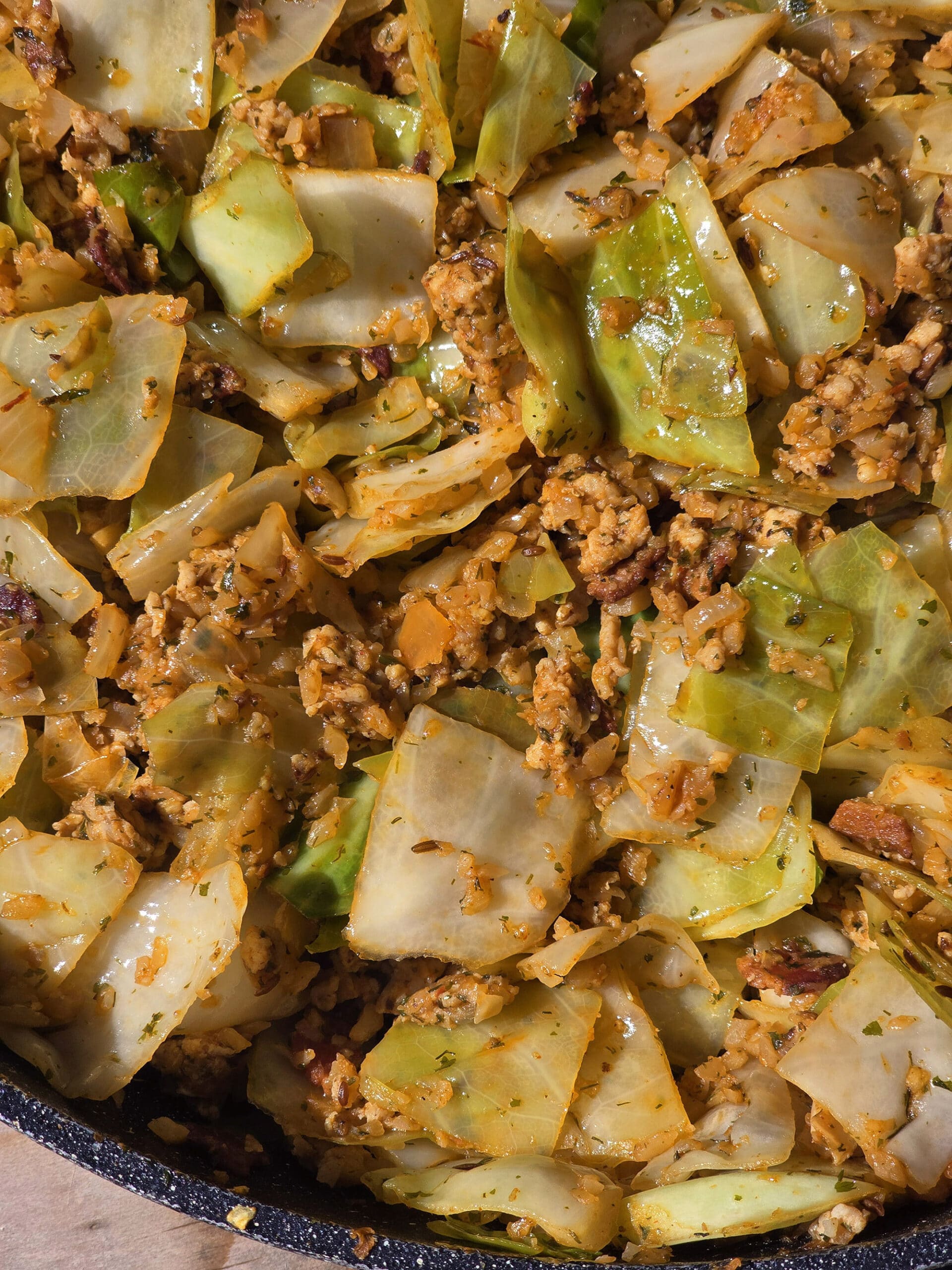 A pan of cabbage roll in a bowl, with ground meat, cabbage, tomato, and more.