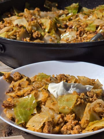 A pan and bowl of lazy cabbage roll stir fry.
