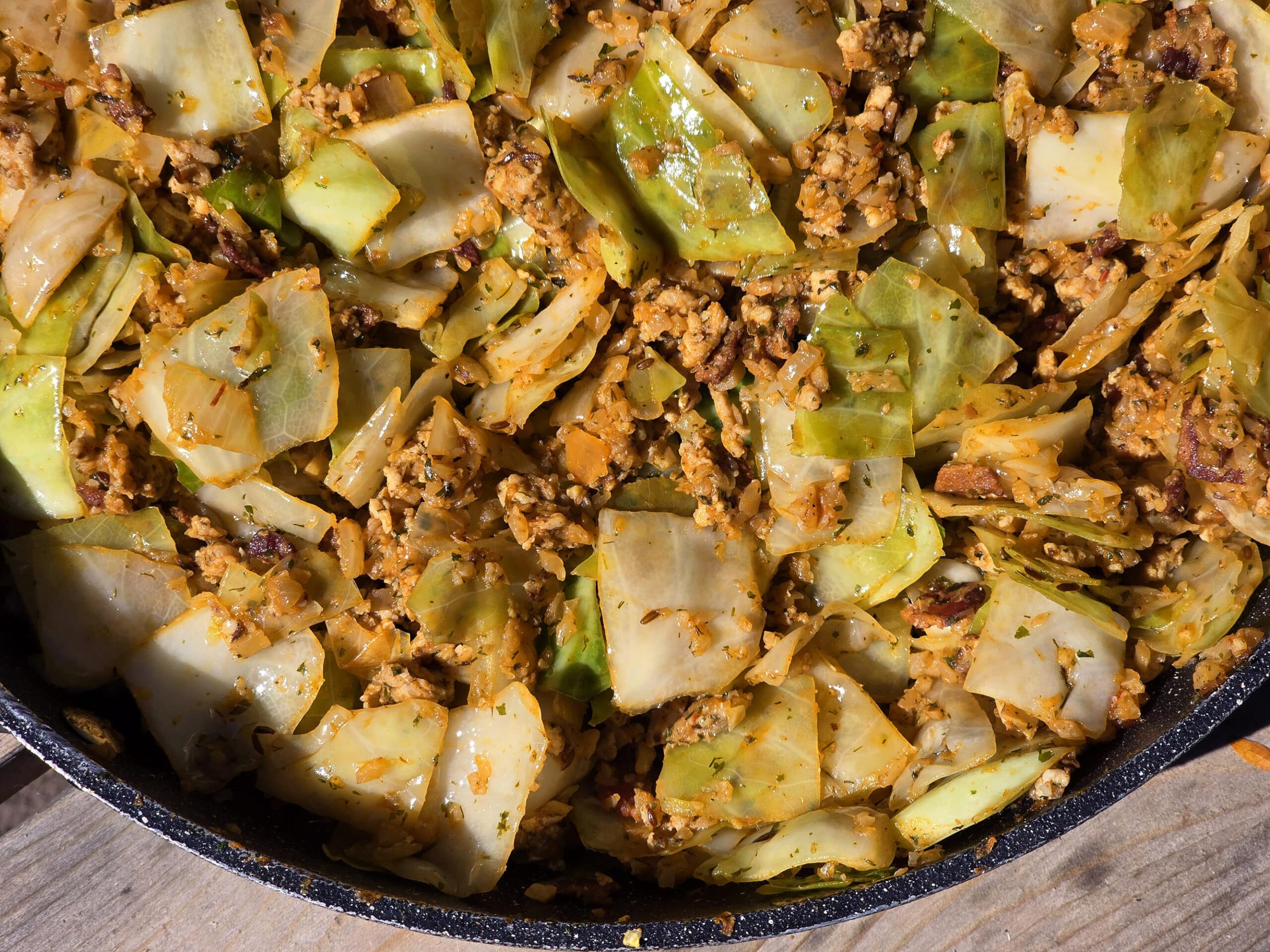 A pan of cabbage roll in a bowl, with ground meat, cabbage, tomato, and more.
